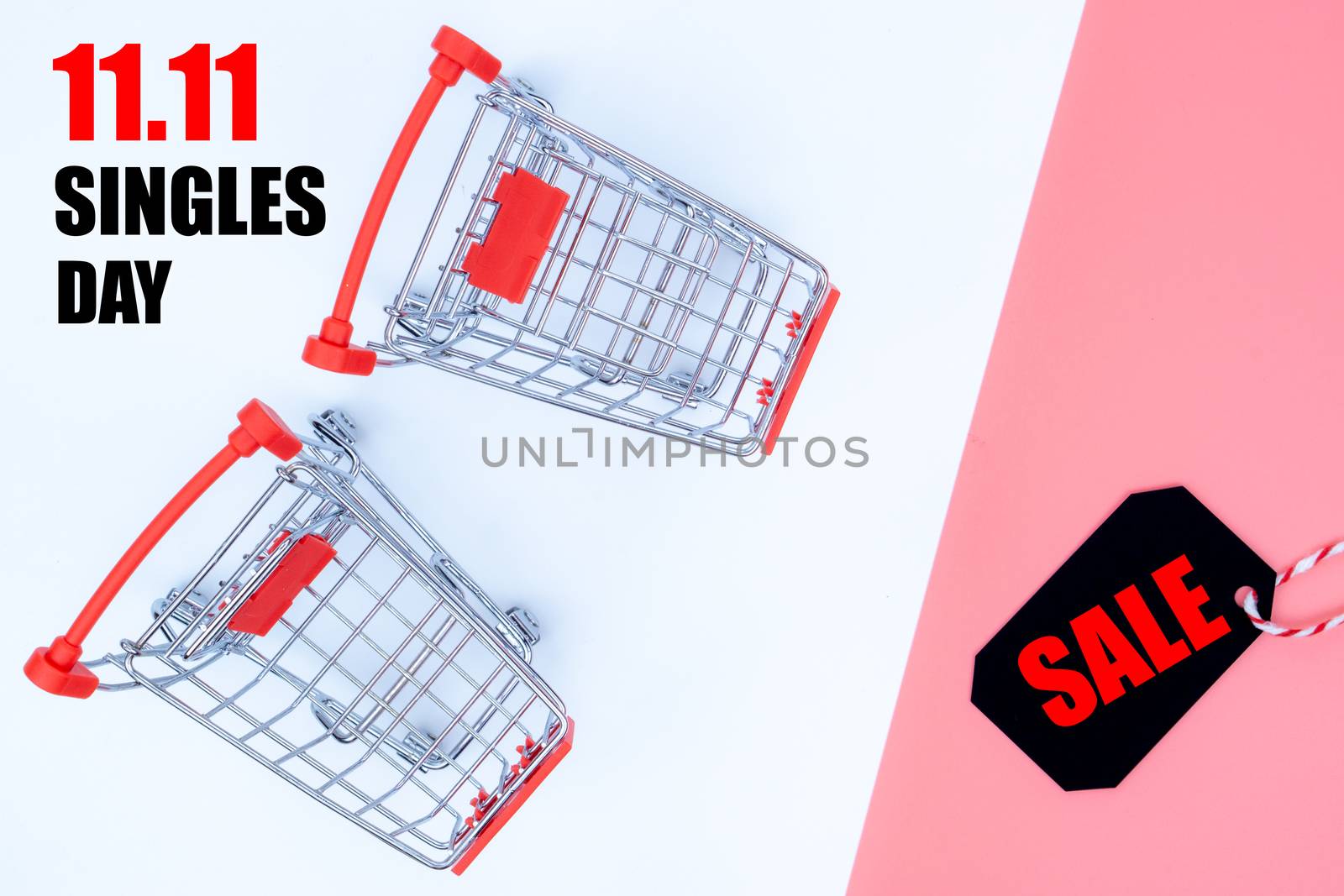 Online shopping of China, The shopping cart and Christmas boxes and shopping tag on a pink and white background with copy space for text. 11.11 single's day sale concept