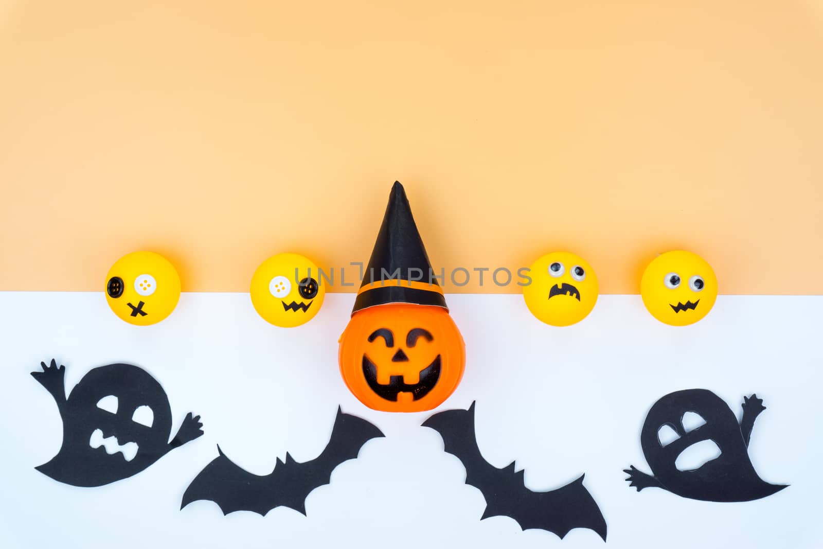 Top view of Halloween decoration, jack o lantern, ghost, bat and spider on yellow background with copy space for text. halloween concept.