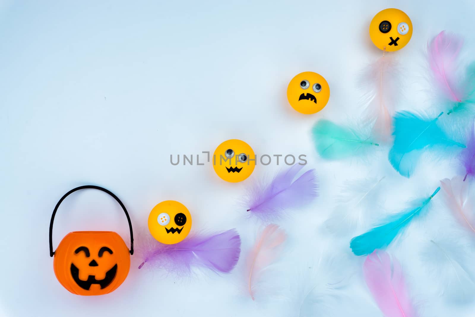 Top view of Halloween decoration, jack o lantern, ghost, bat and colorful feather on white background with copy space for text. halloween concept.