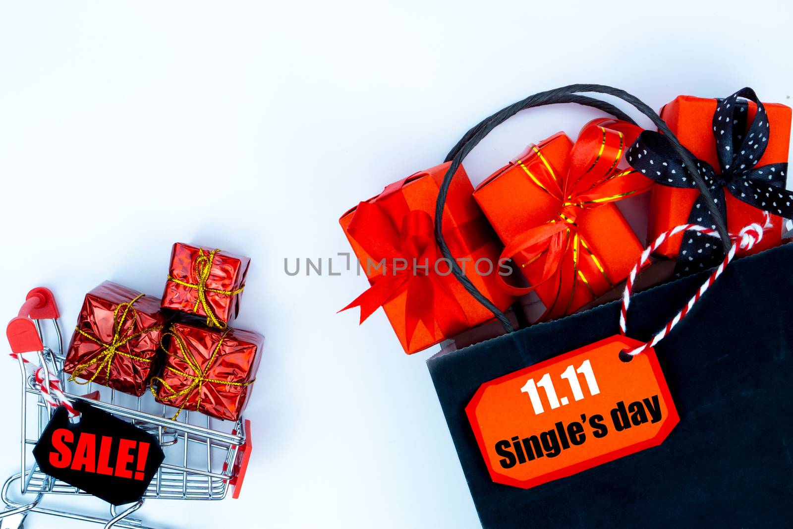 The shopping cart and Christmas boxes with red ribbon on a white background with copy space for text.Online shopping of China, 11.11 single's day sale concept