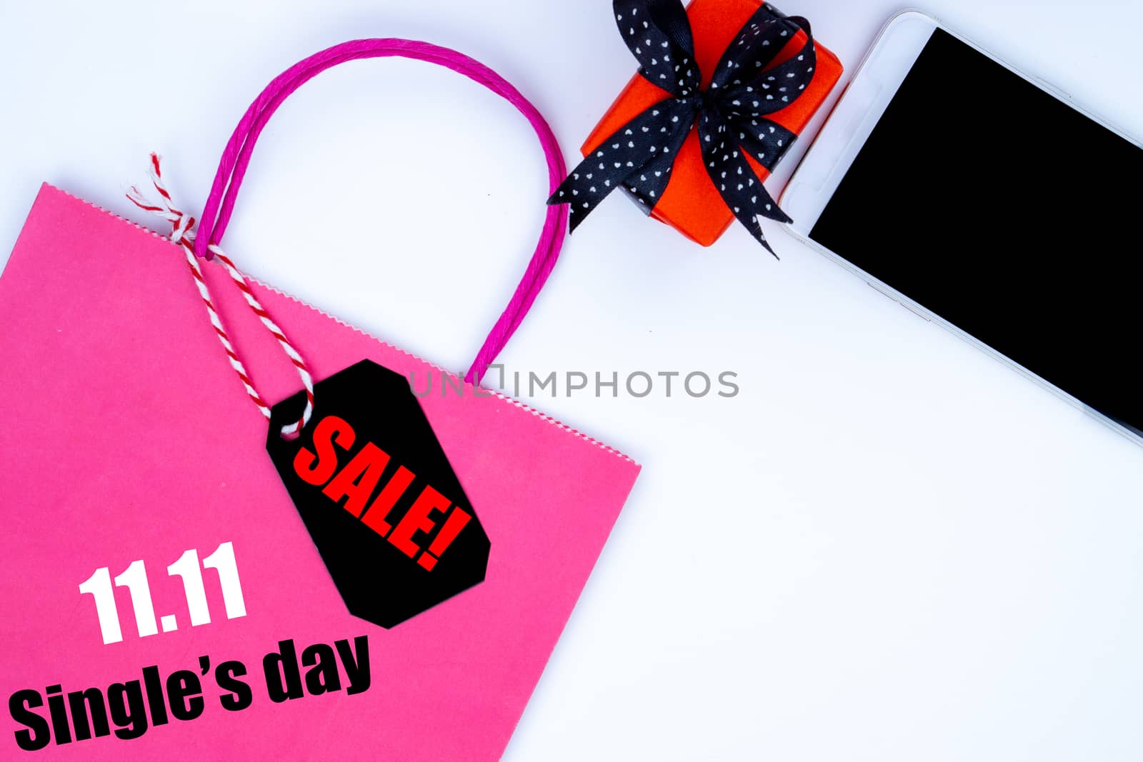 The shopping bag and Christmas boxes with black ribbon and smartphone on a white background with copy space for text.Online shopping of China, 11.11 single's day sale concept
