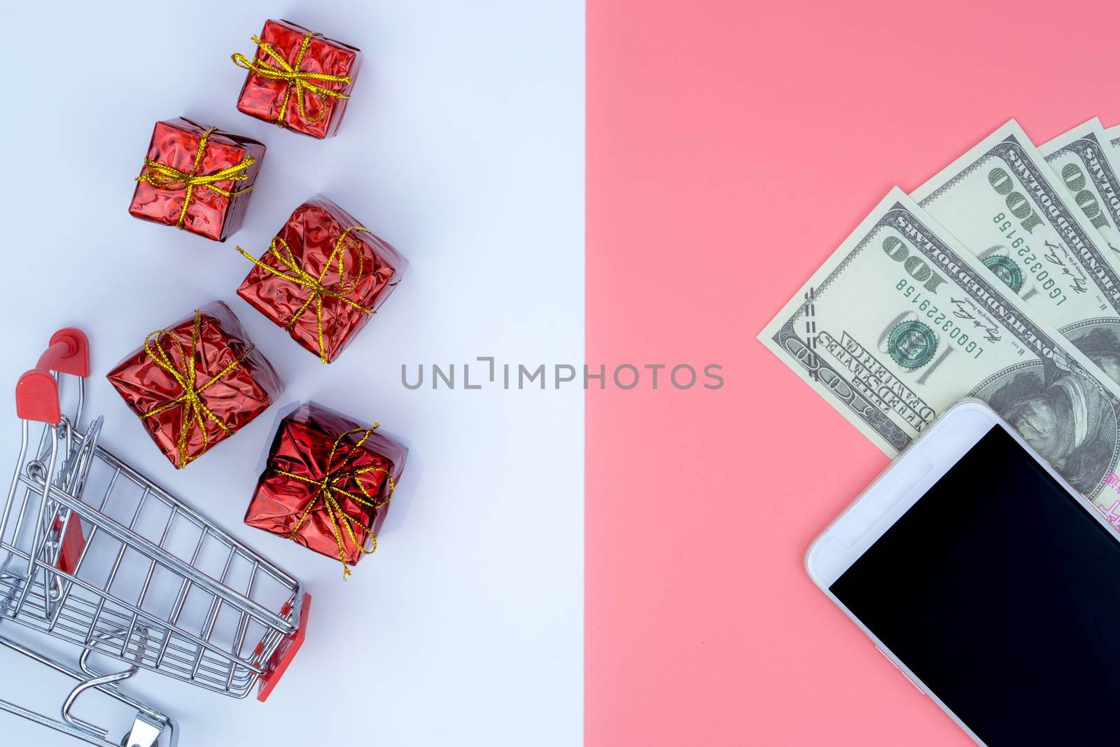 Online shopping of China, The shopping cart and Christmas boxes and banknote and smartphone on a white and pink background with copy space for text. 11.11 single's day sale concept