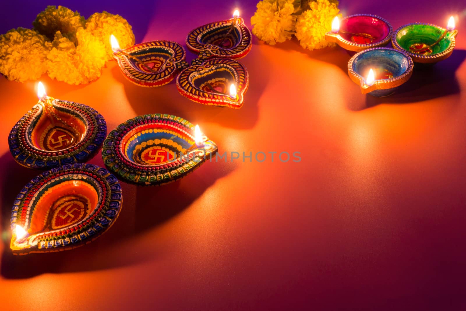 Indian festival Diwali, Diya oil lamps lit on colorful rangoli.  by mikesaran