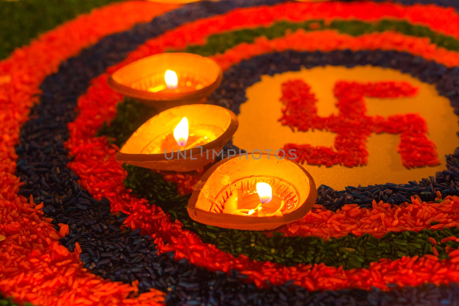 Indian festival Diwali, Diya oil lamps lit on colorful rangoli with Swastika symbol. Hindu traditional. Happy Deepavali.