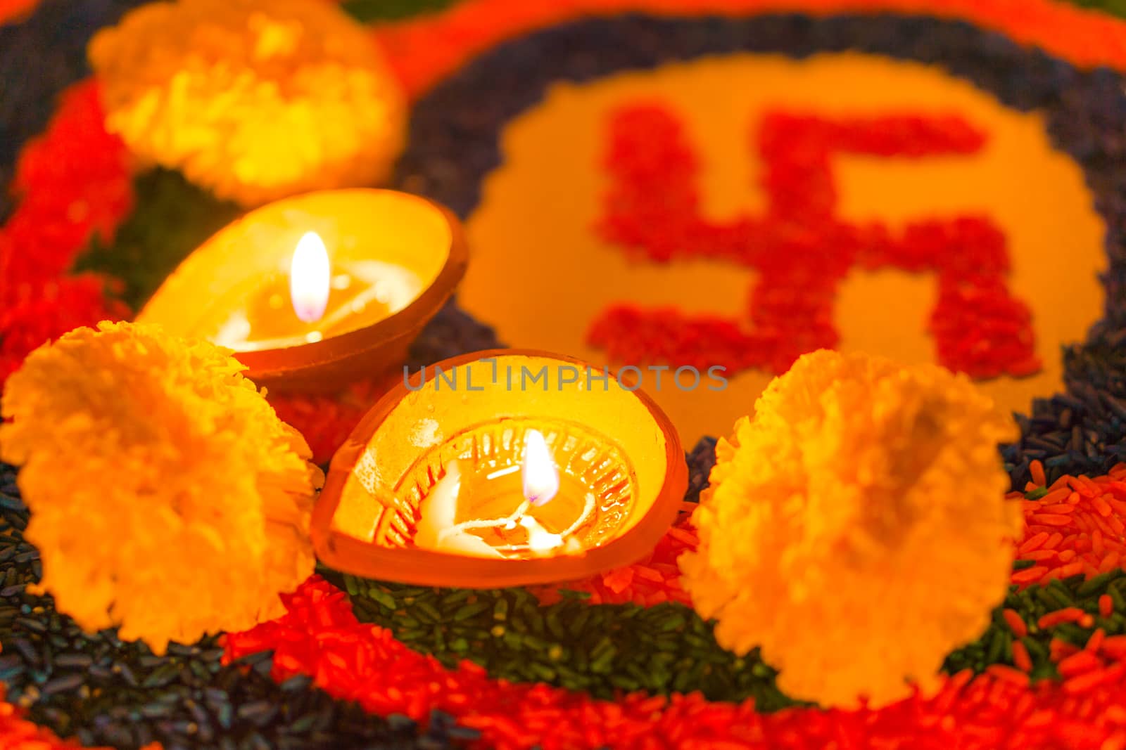 Indian festival Diwali, Diya oil lamps lit on colorful rangoli with Swastika symbol. Hindu traditional. Happy Deepavali.