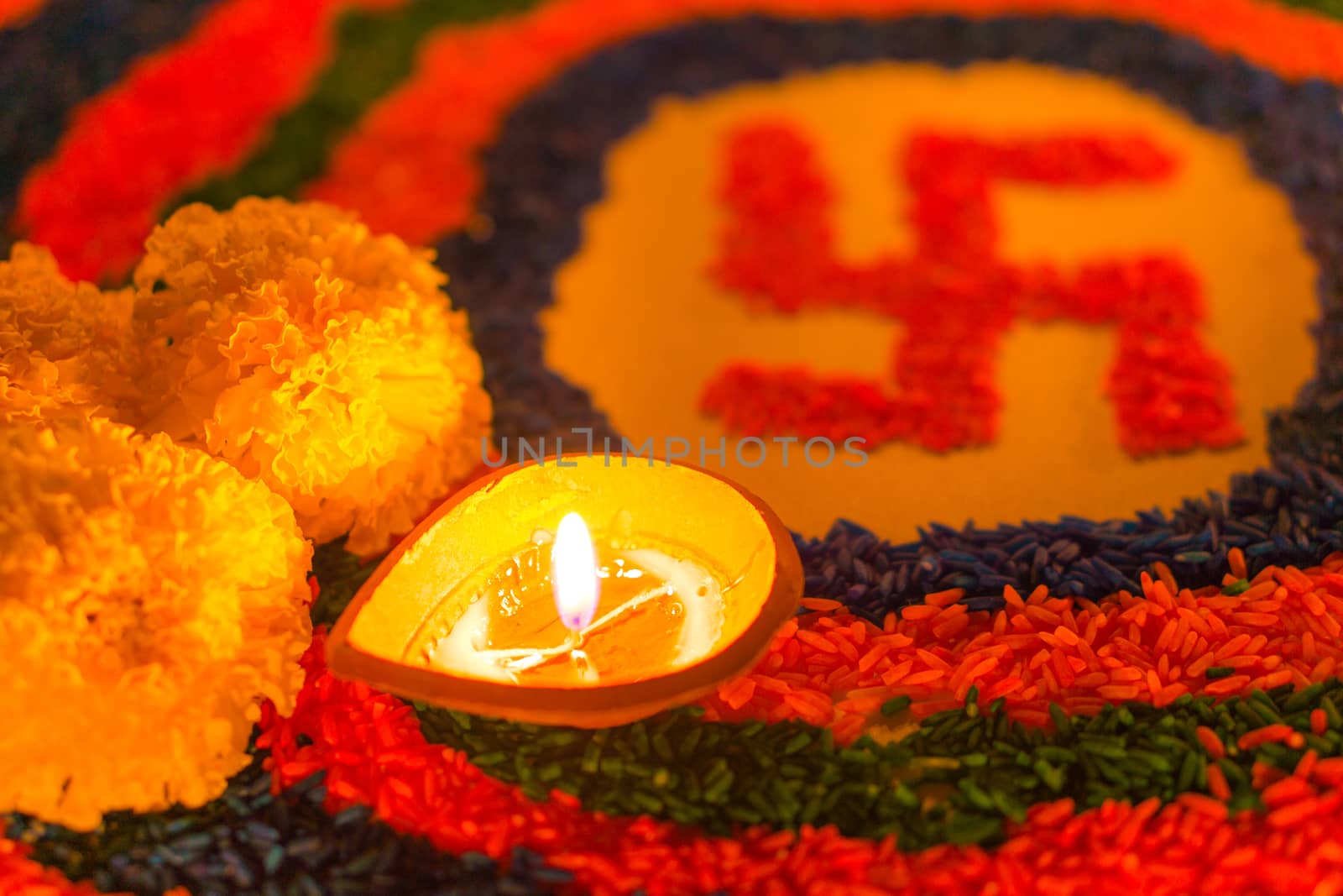 Indian festival Diwali, Diya oil lamps lit on colorful rangoli w by mikesaran