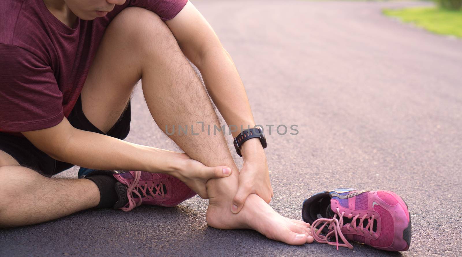 Ankle sprained. Young man suffering from an ankle injury while running at park. Healthcare and sport concept.