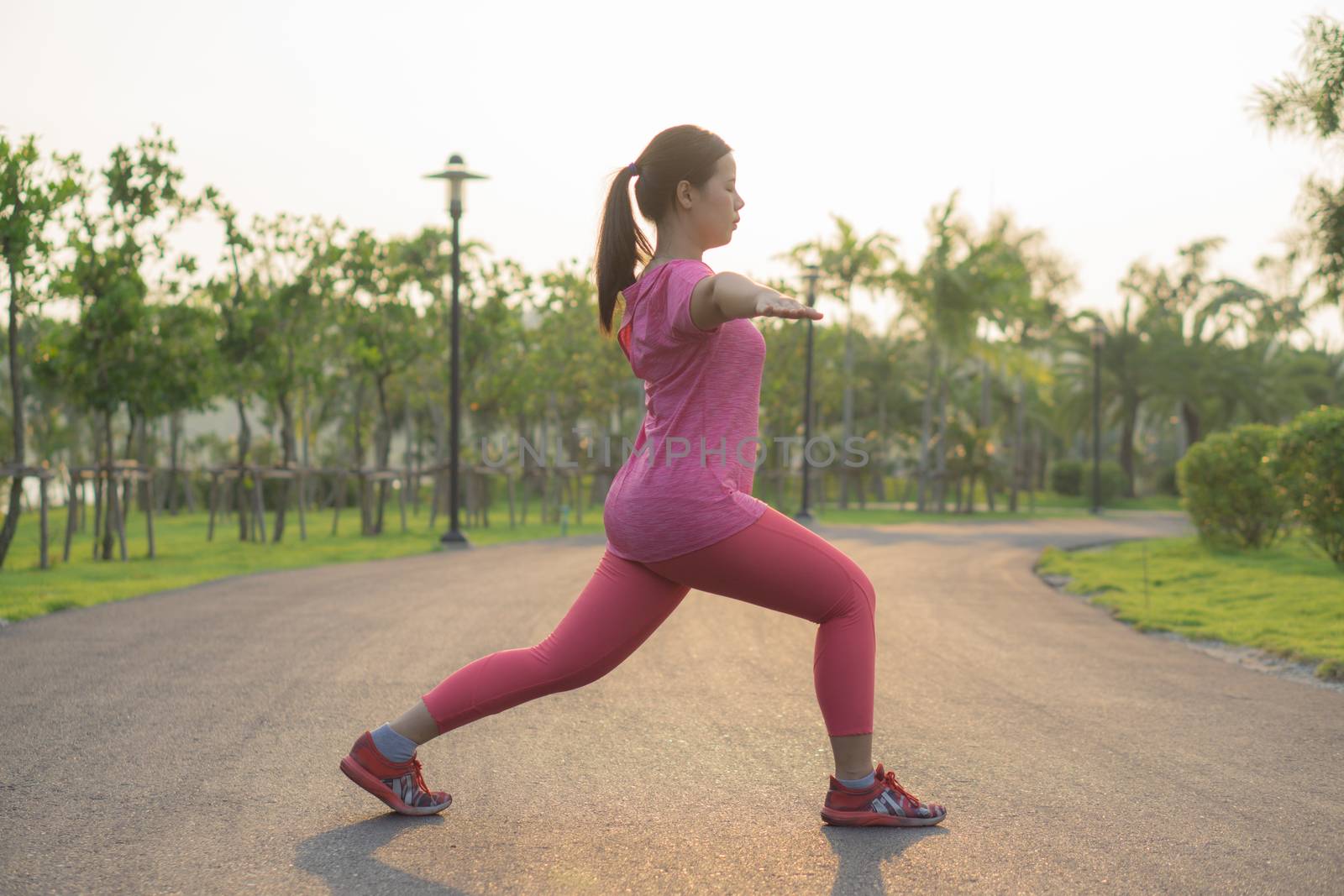 Asian woman practicing yoga in a garden. Healthy lifestyle and relaxation concept