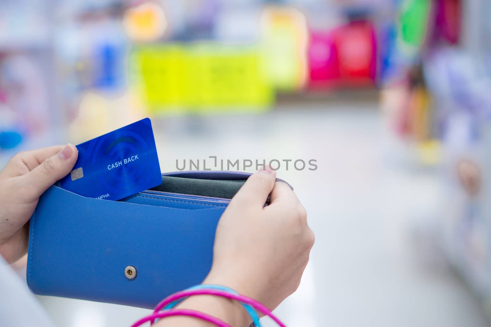 Close up woman hand holding purse, shopping bag and credit card in the shopping mall. Shopping concept.