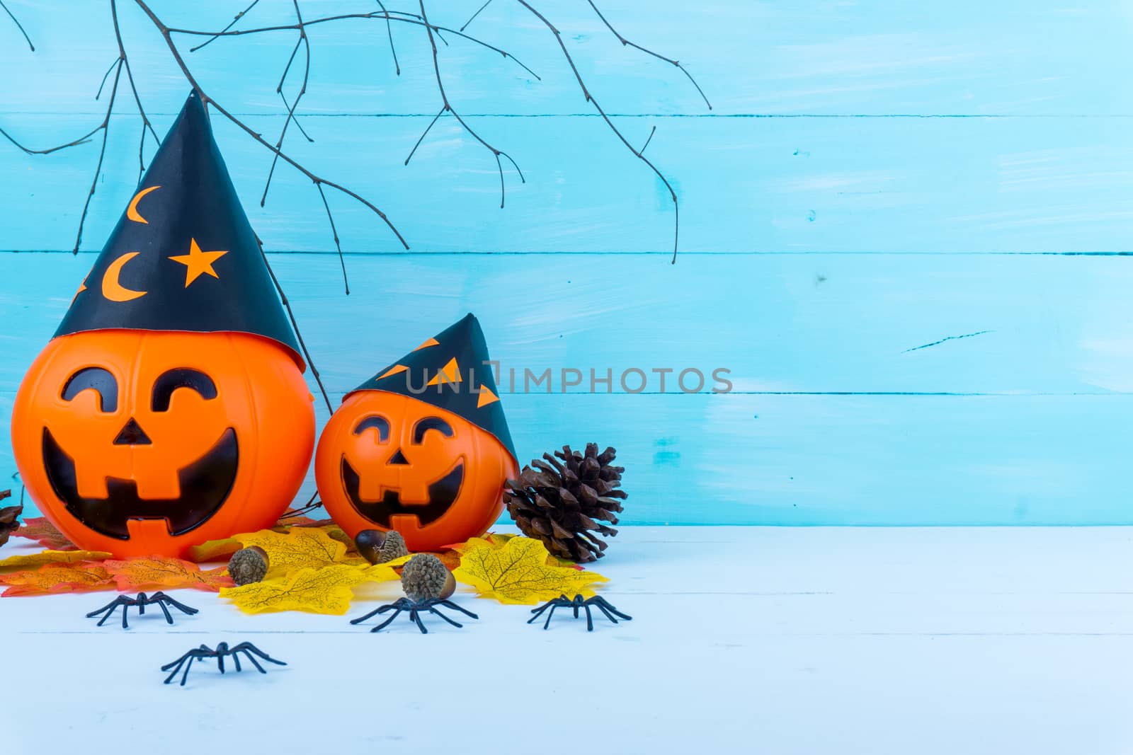 Halloween holiday background with spider, webs, gifts and jack lantern on blue wooden table with copy space for text. Flat lay, top view