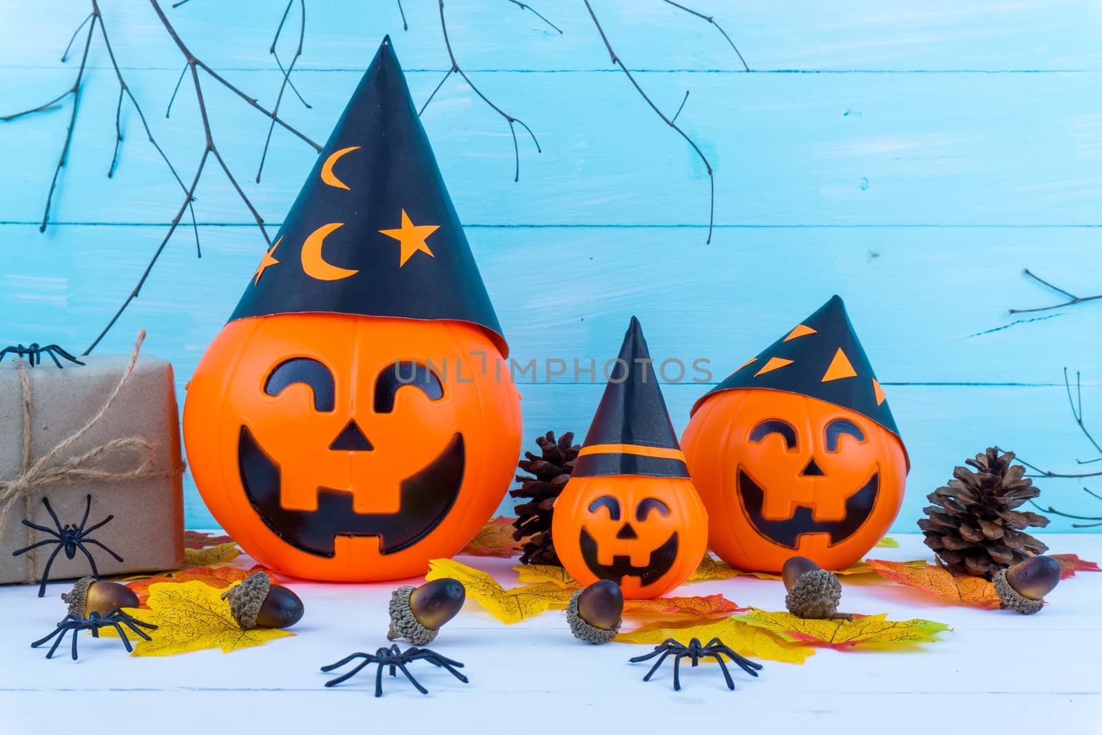 Halloween holiday background with spider, webs, gifts and jack lantern on blue wooden table with copy space for text. Flat lay, top view