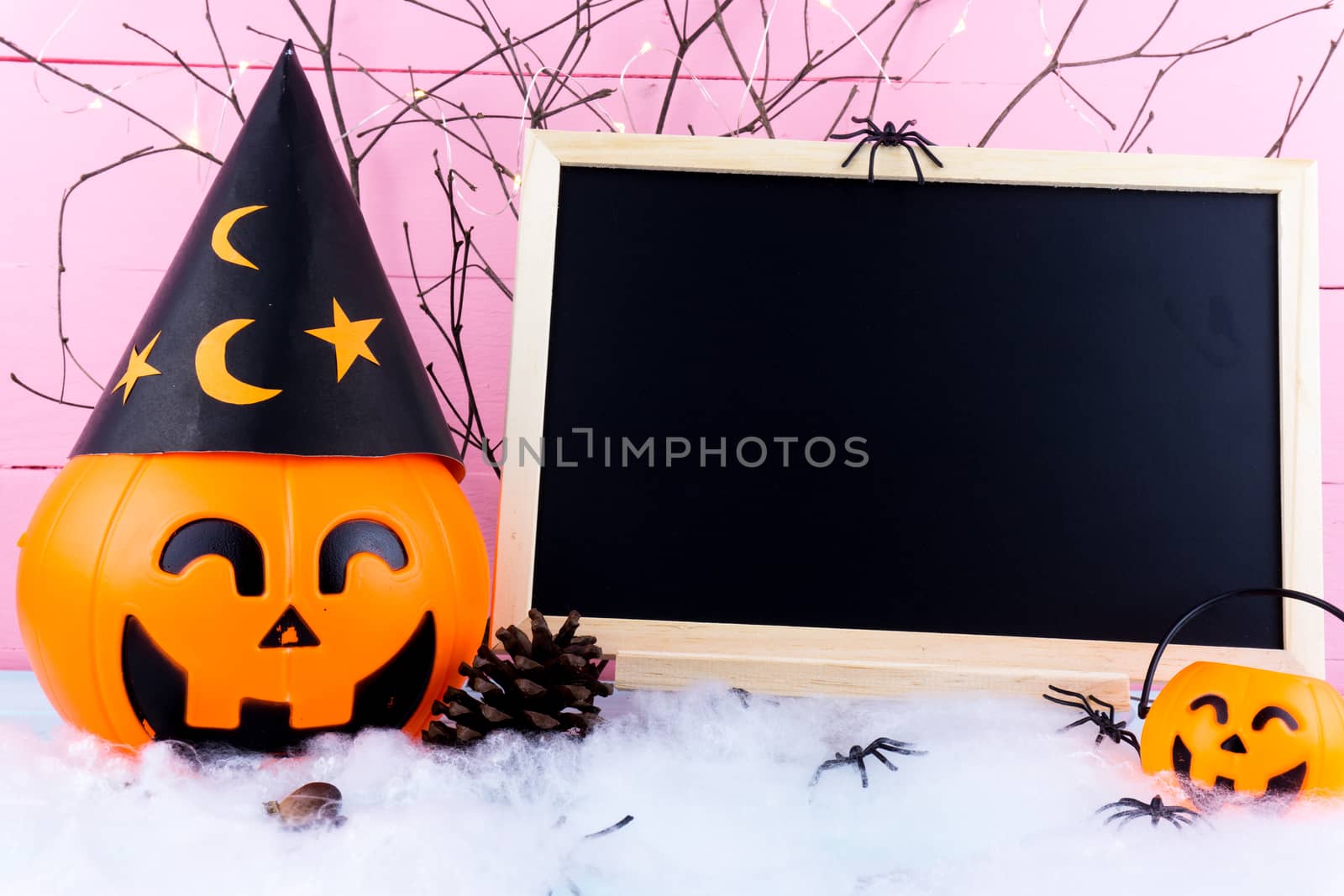 Halloween holiday background with spider, webs, blackboard and jack lantern on blue wooden table with copy space for text. Flat lay, top view
