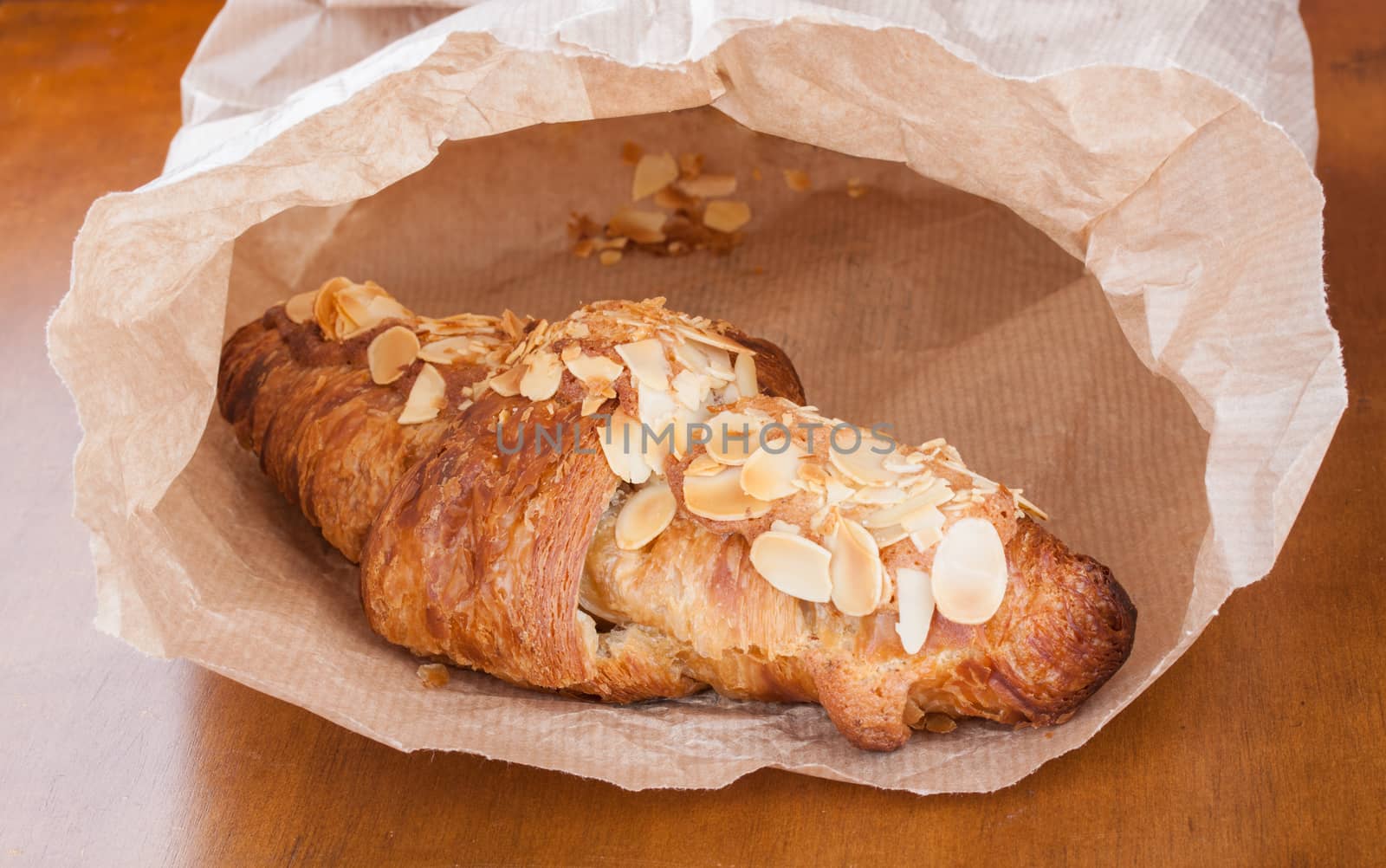 Fresh delicious almond crescent from bakery in a brown paper bag
