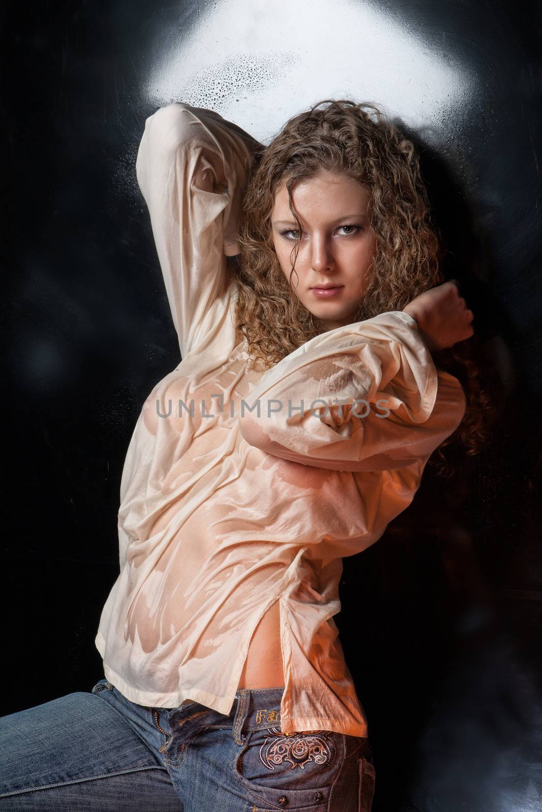 Young woman on a reflecting studio background