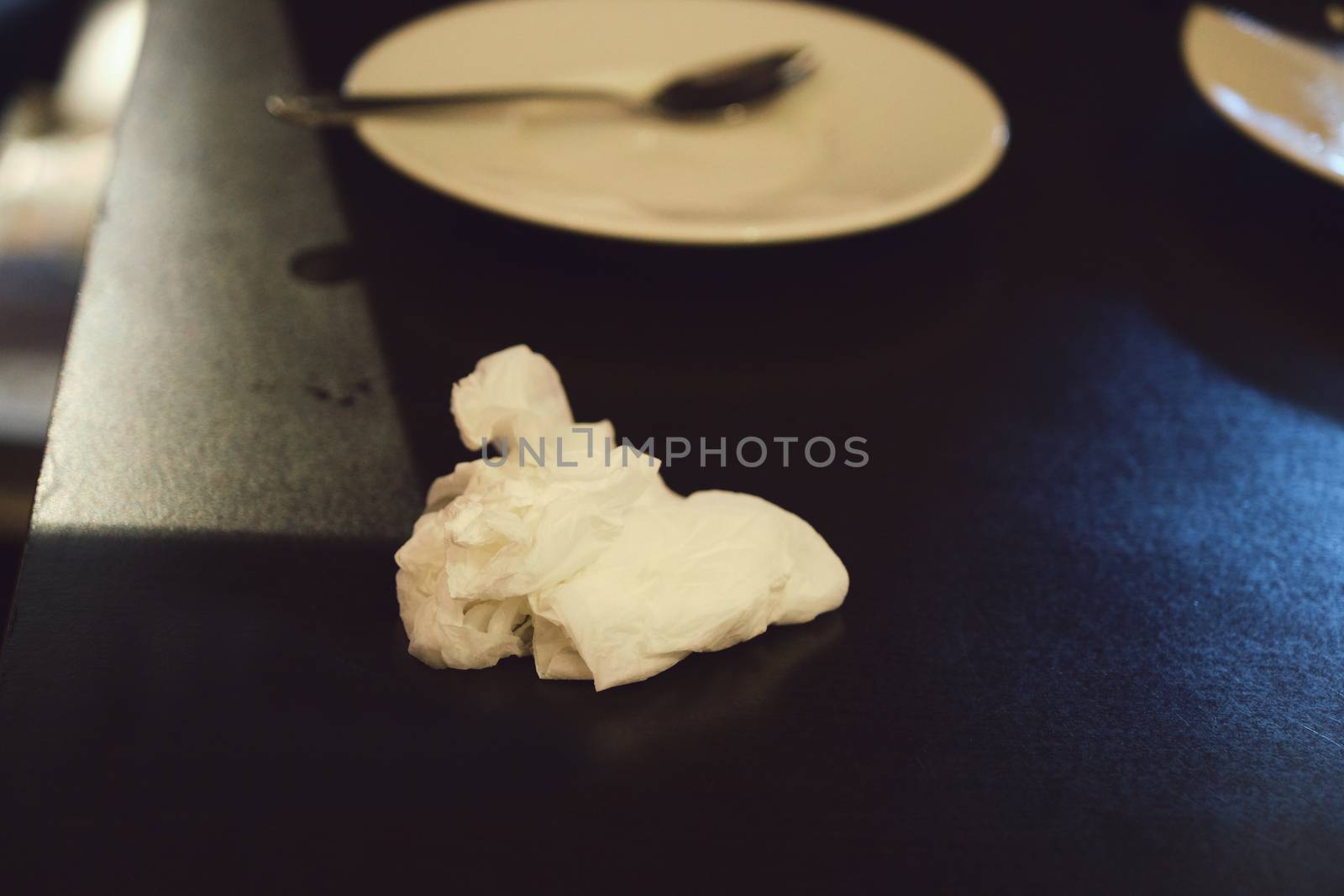 The Crumpled Tissue Paper Texture after use for cold and flu season or cleaning concept, placed on wooden table, closeup with blurred background