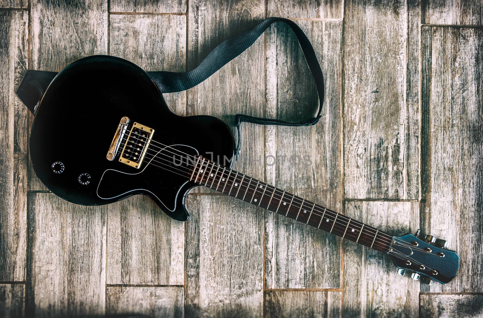 electric guitar grunge look studio shot up view on wooden background .