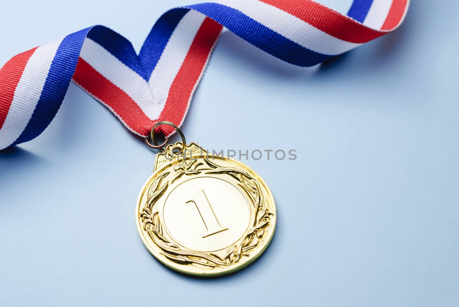 Gold medal 1 place with a ribbon on a light blue background, the concept of victory or success