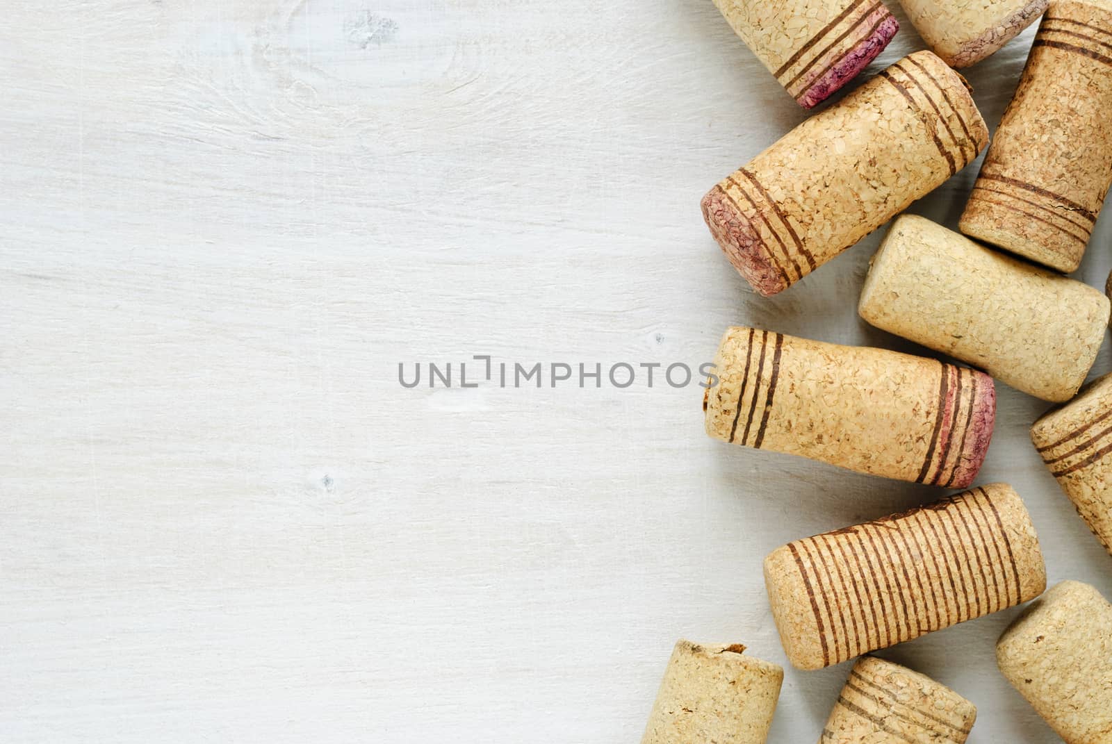 Set of used wine bottle corks, viewed in closeup with white table surface as copy space to the left