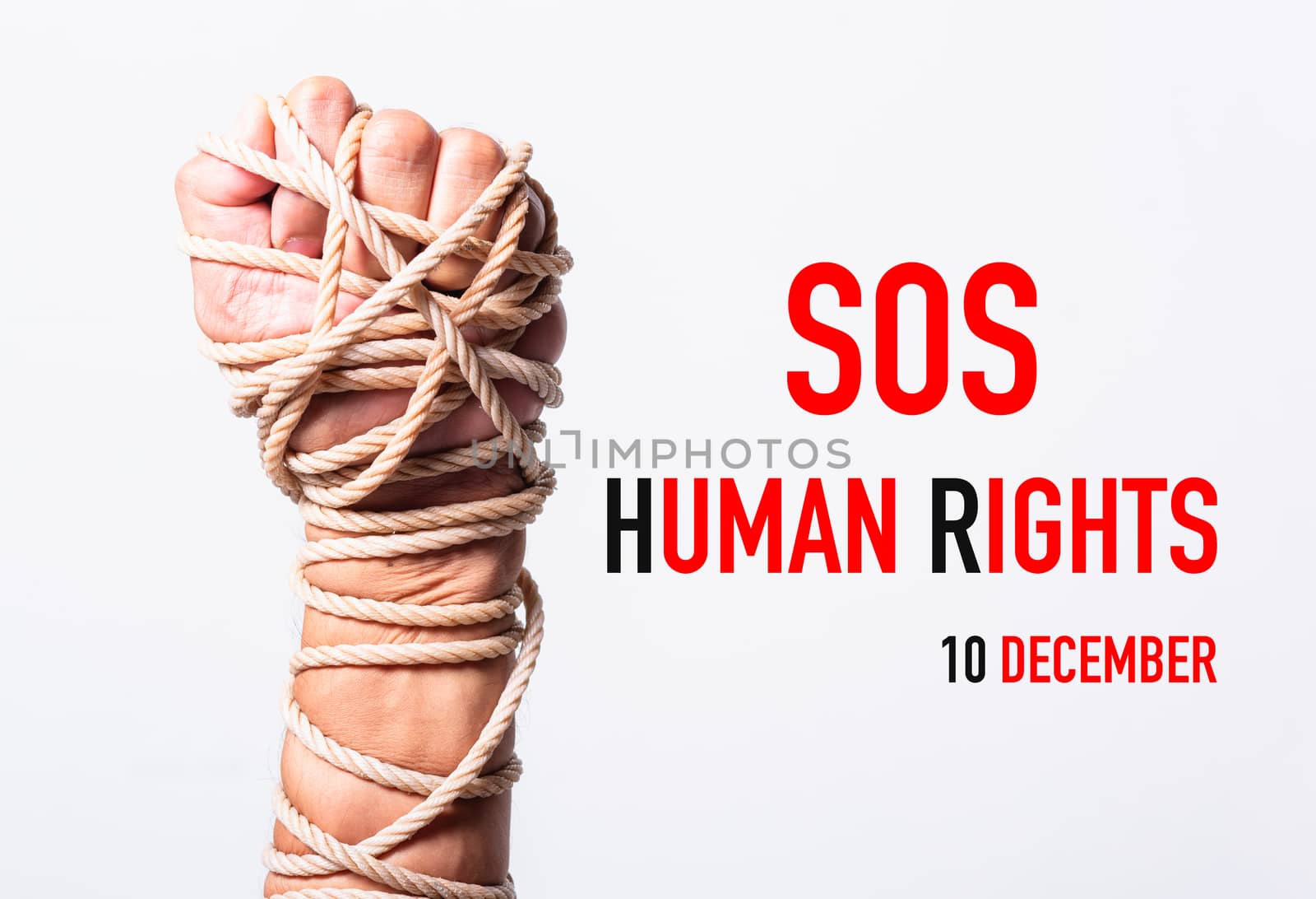 Rope on fist hand with SOS HUMAN RIGHTS DAY 10 december text on white background, Human rights day concept
