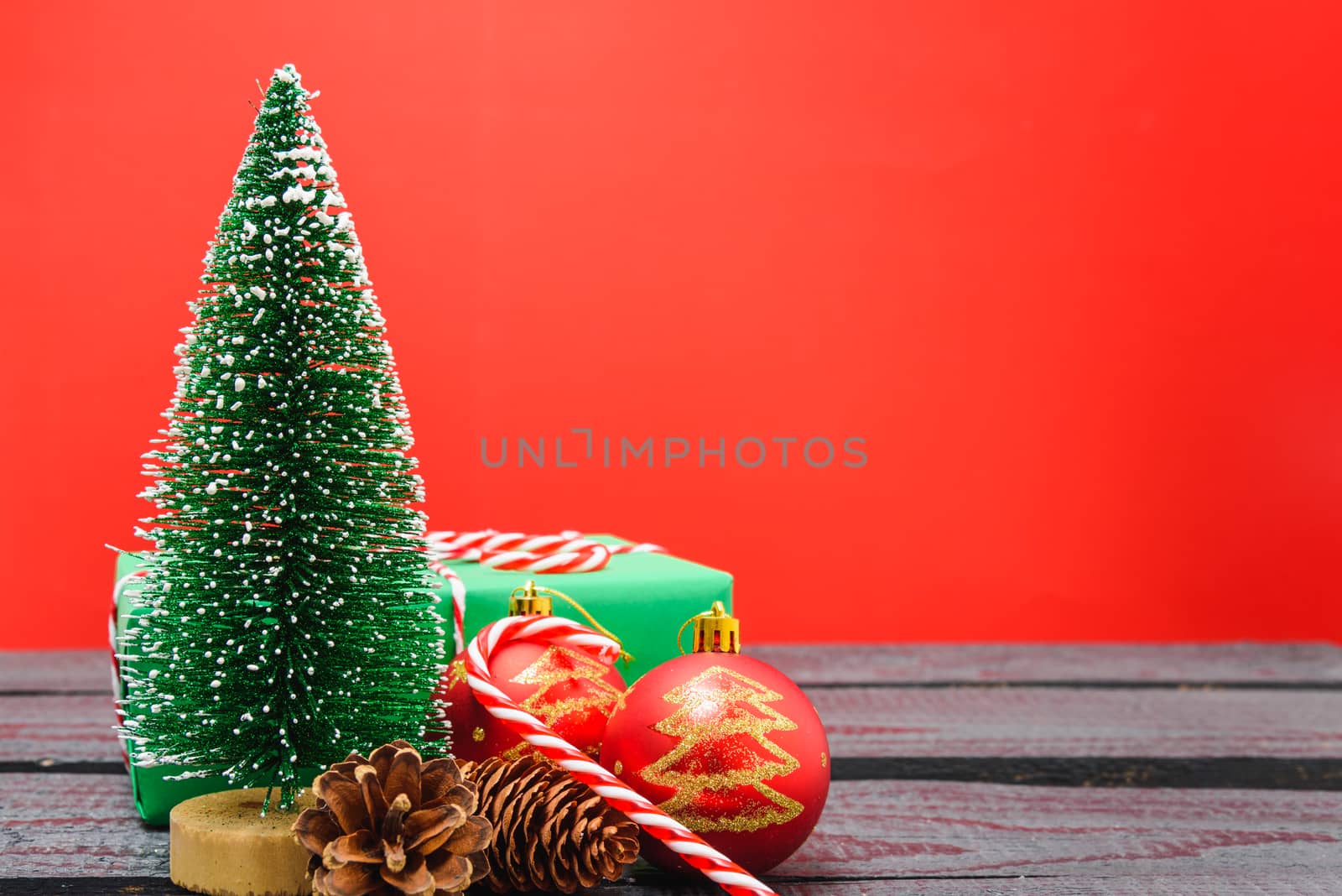 Christmas composition and decorations, minimal green fir tree branches with snow on red background. Merry Christmas concept. Copy space for text
