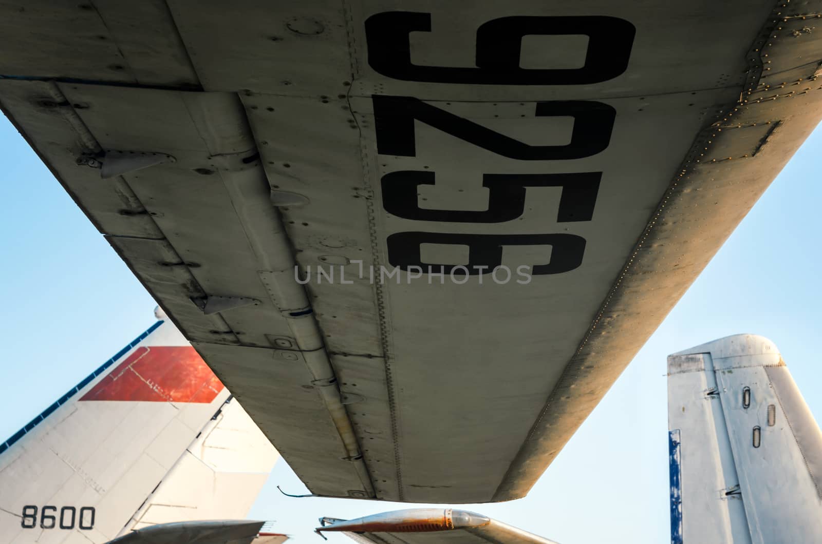 wing with tail number on the background of airplanes and blue sky close up