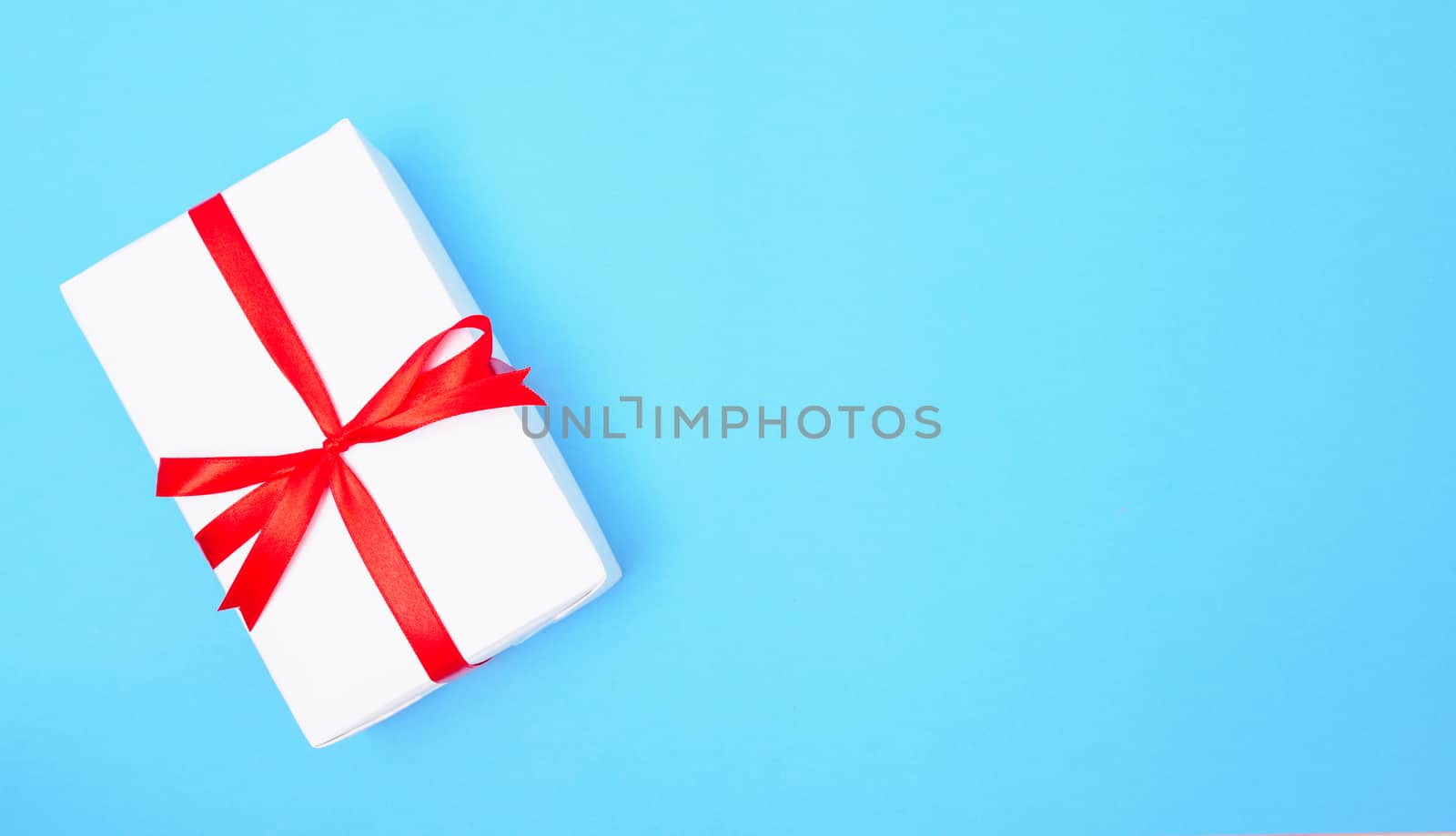 Happy New Year and Christmas 2020 or valentine day, top view craft paper wrapped present white gift box craft on blue background with copy space for your text