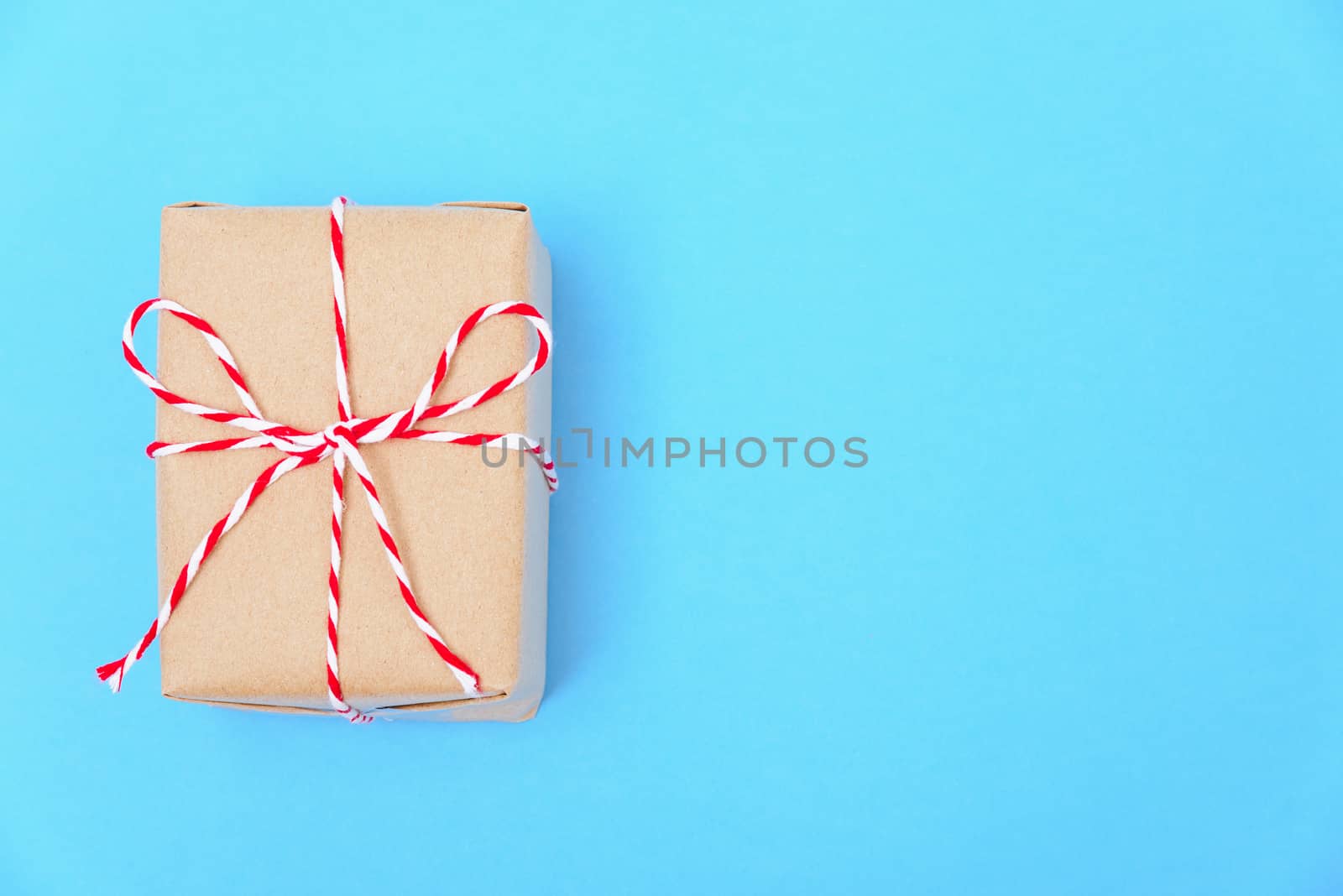 Happy New Year and Christmas 2020 or valentine day, top view craft paper wrapped present Brown gift box craft on blue background with copy space for your text