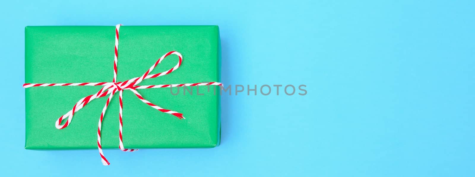 Happy New Year and Christmas 2020 or valentine day, top view craft paper wrapped present green gift box craft on blue background with copy space for your text