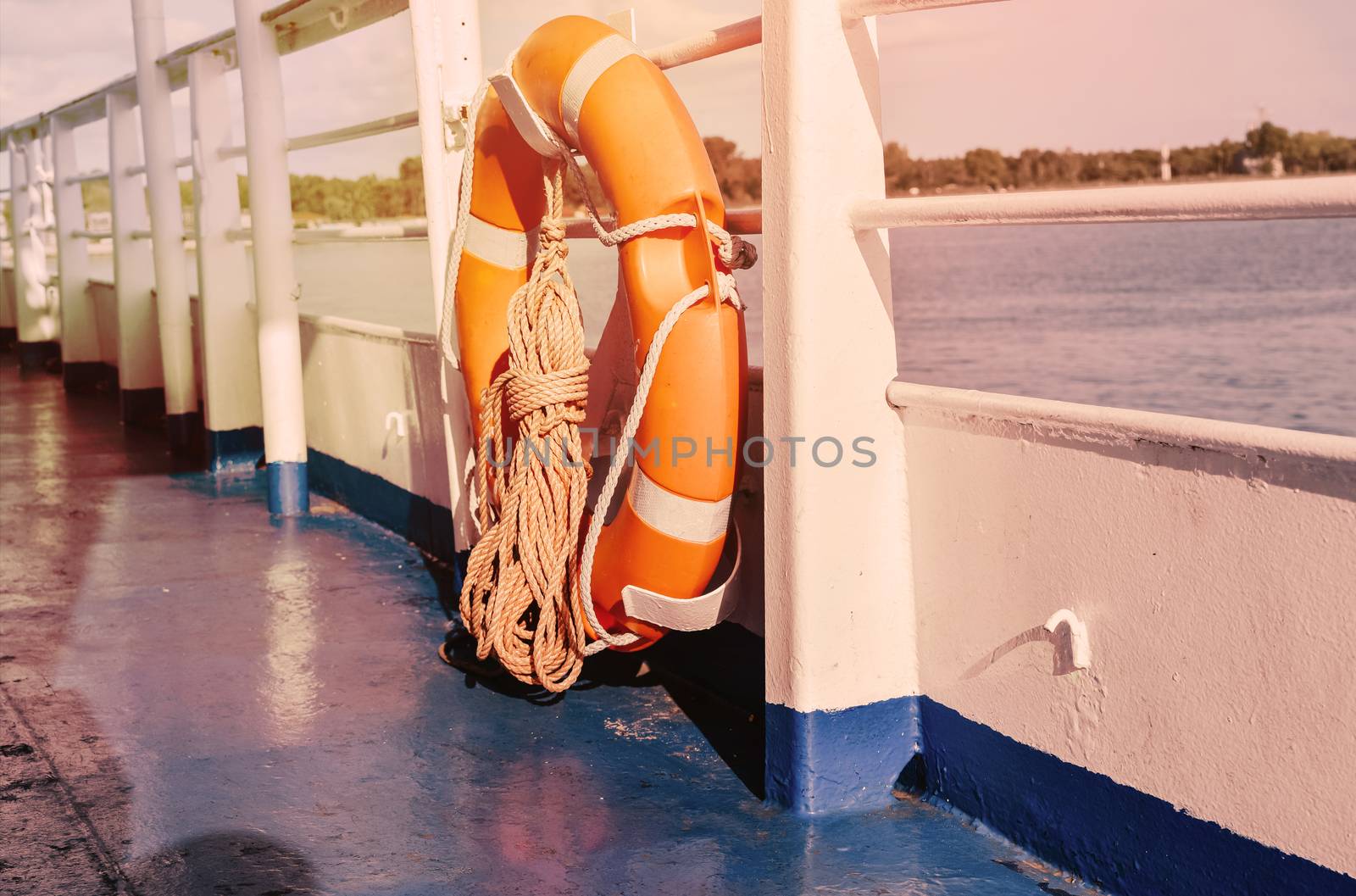 Red Lifebuoy in front of the blue sea and the white ship