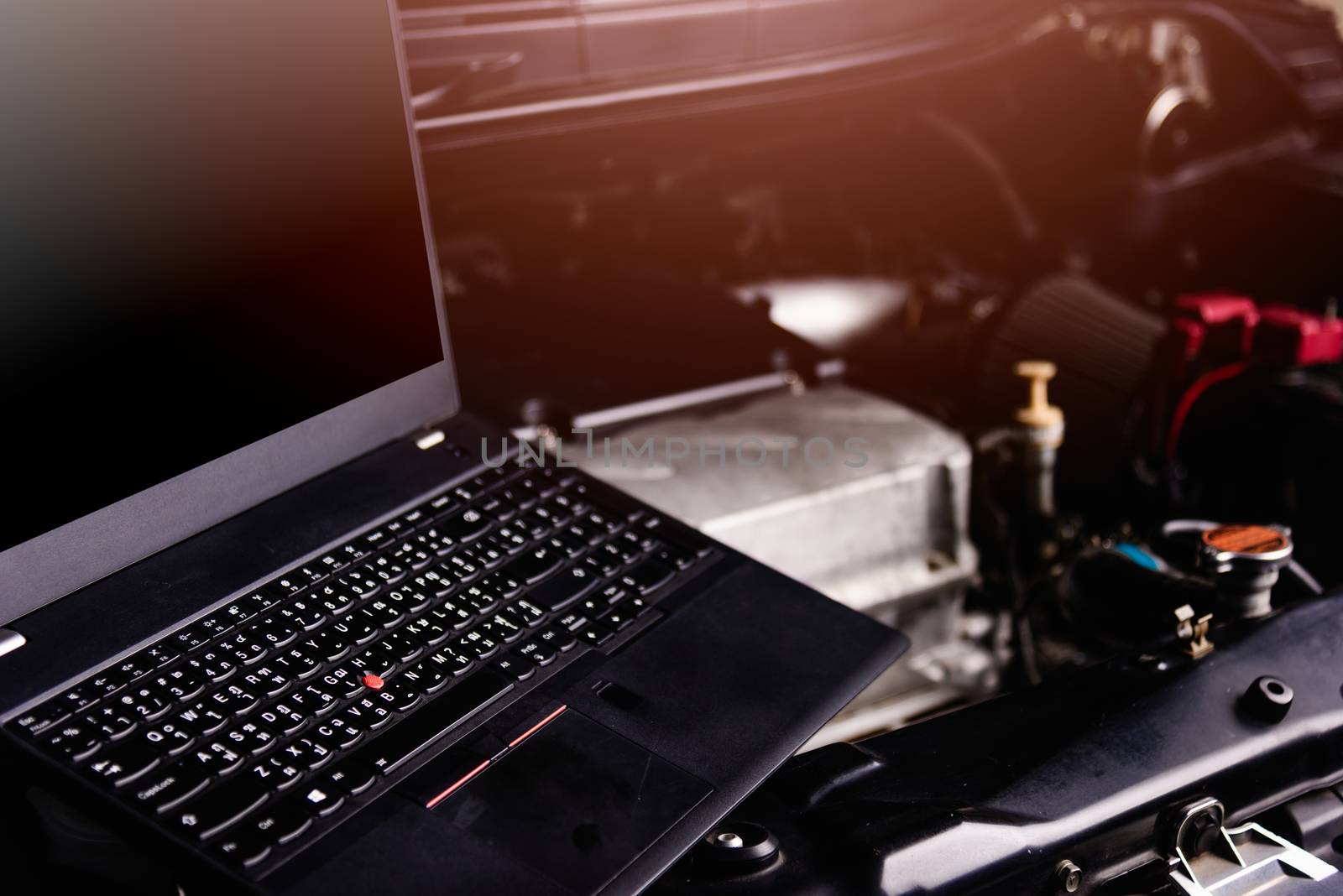 Laptop computer on car mechanic engine for service at workshop