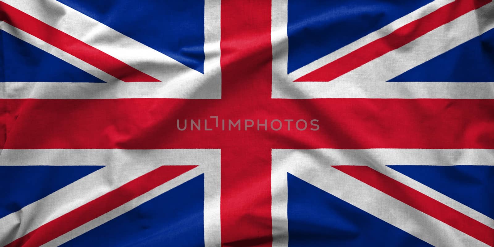 Union Jack wide silk flag of The United Kingdom of Great Britain and Northern Ireland blowing in the wind in full frame background concept