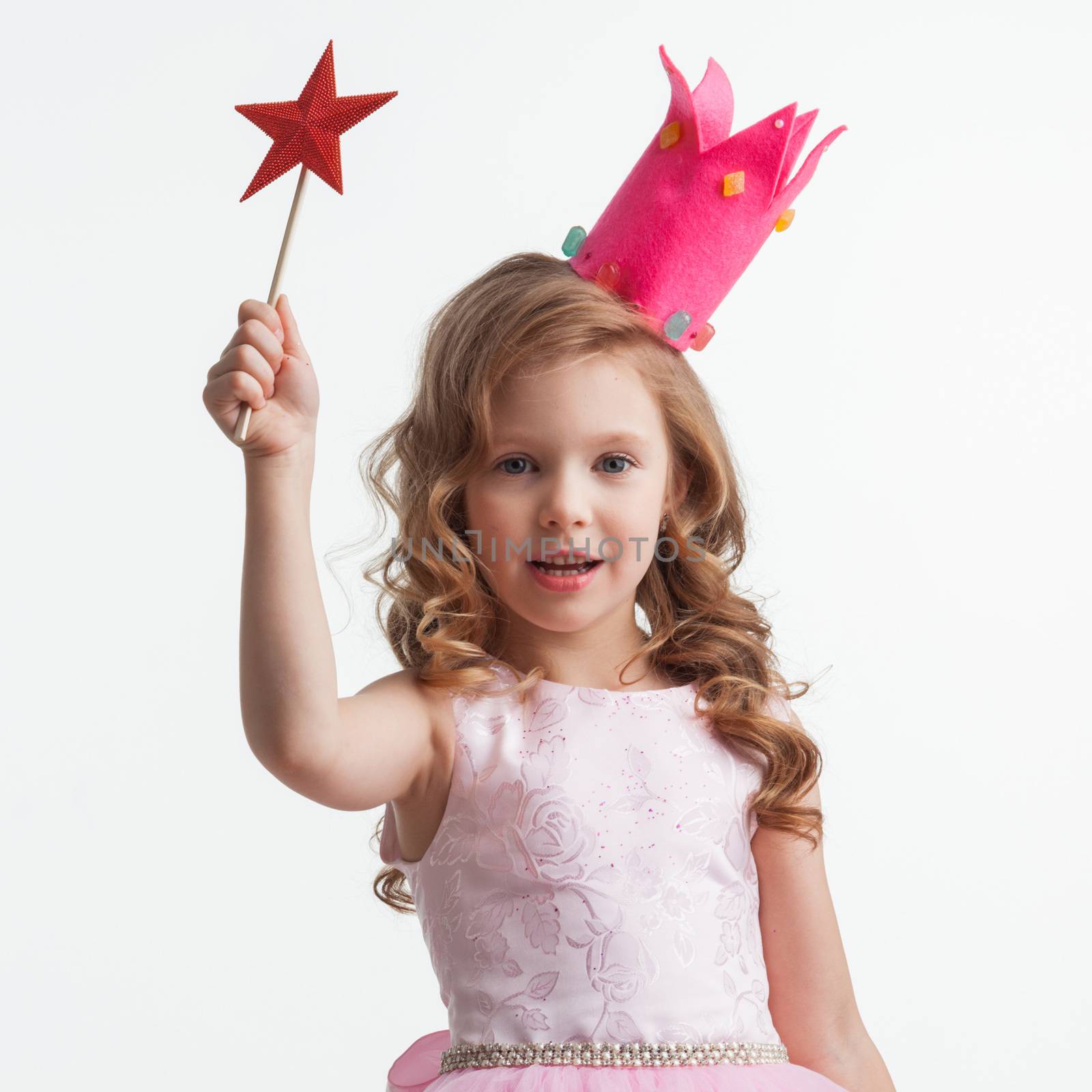 Beautiful little candy princess girl in crown holding star shaped magic wand and making a wish spell isolated on white background