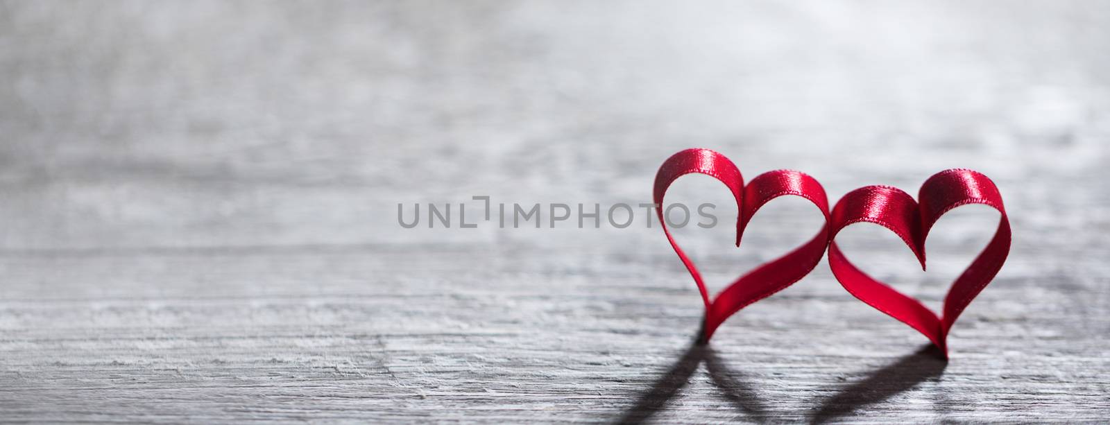 Two red ribbon hearts on wooden background with copy space for text, Valentines day concept