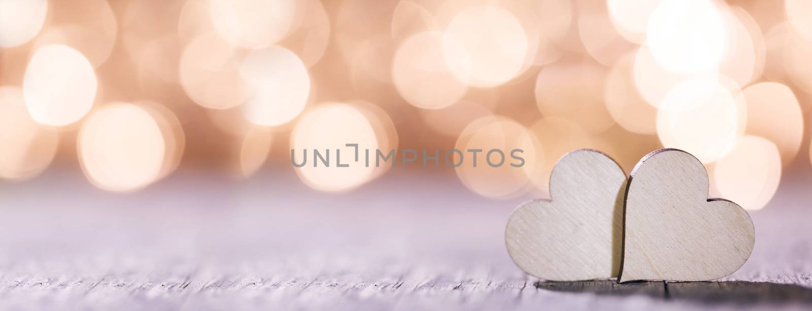 Two handmade wooden hearts on beautiful golden bokeh background. Vintage style. Love Valentine's Day concept.