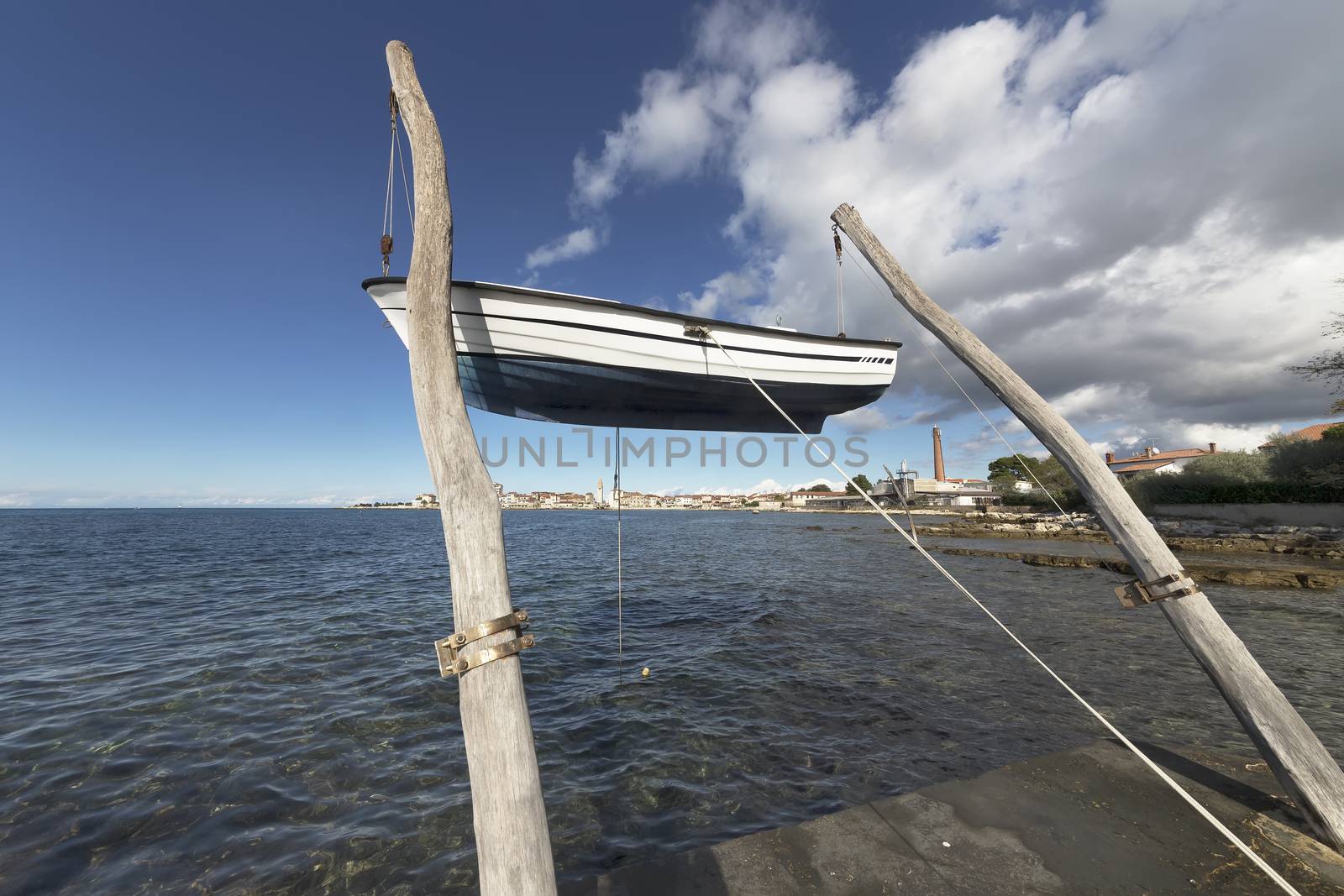 hanging boat on the beach in front of the town of Umag, Istria, Croatia