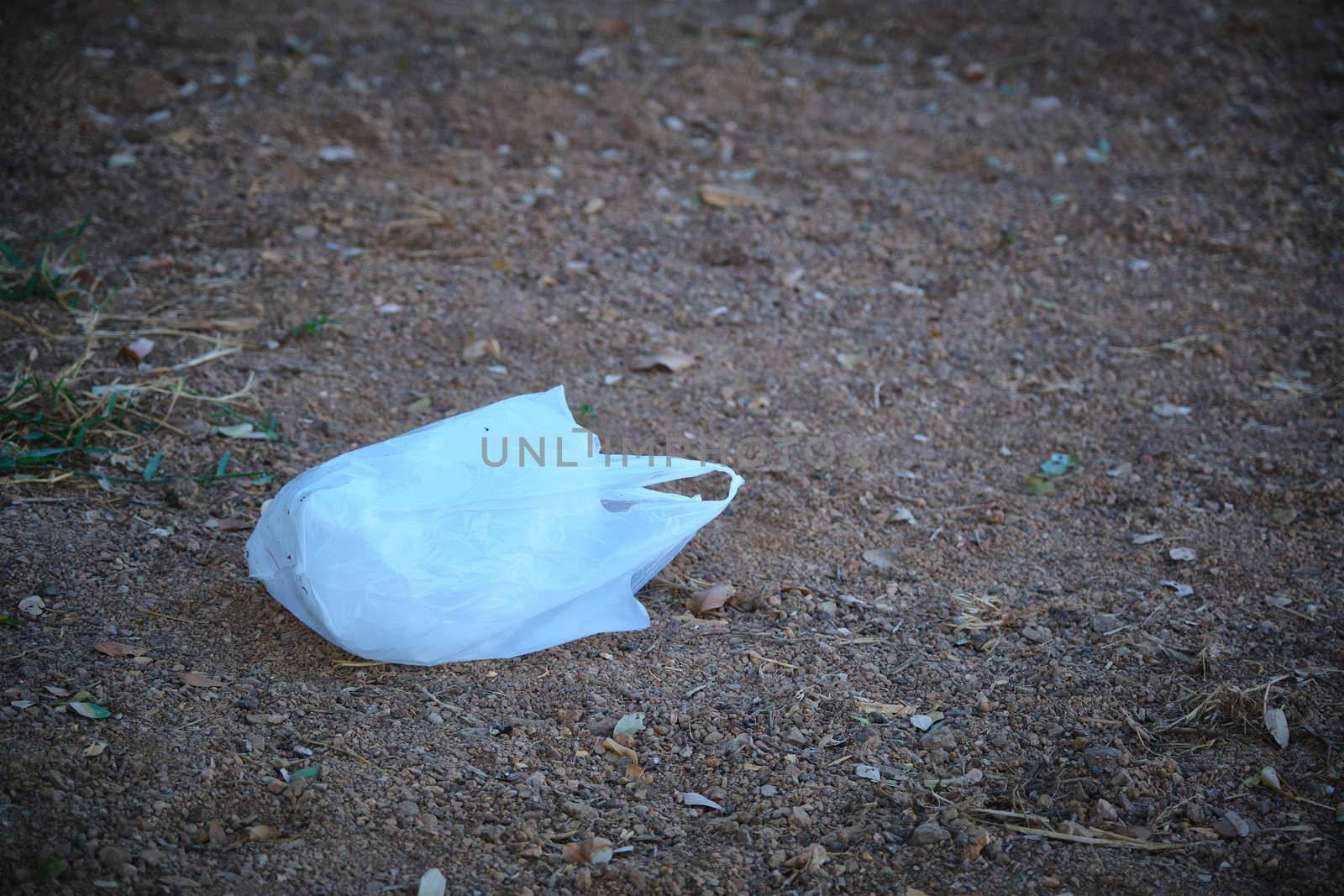 waste plastic bag, dirty plastic bag on the ground, old bag waste, dirty plastic waste, plastic waste is polluting the environment (selective focus)