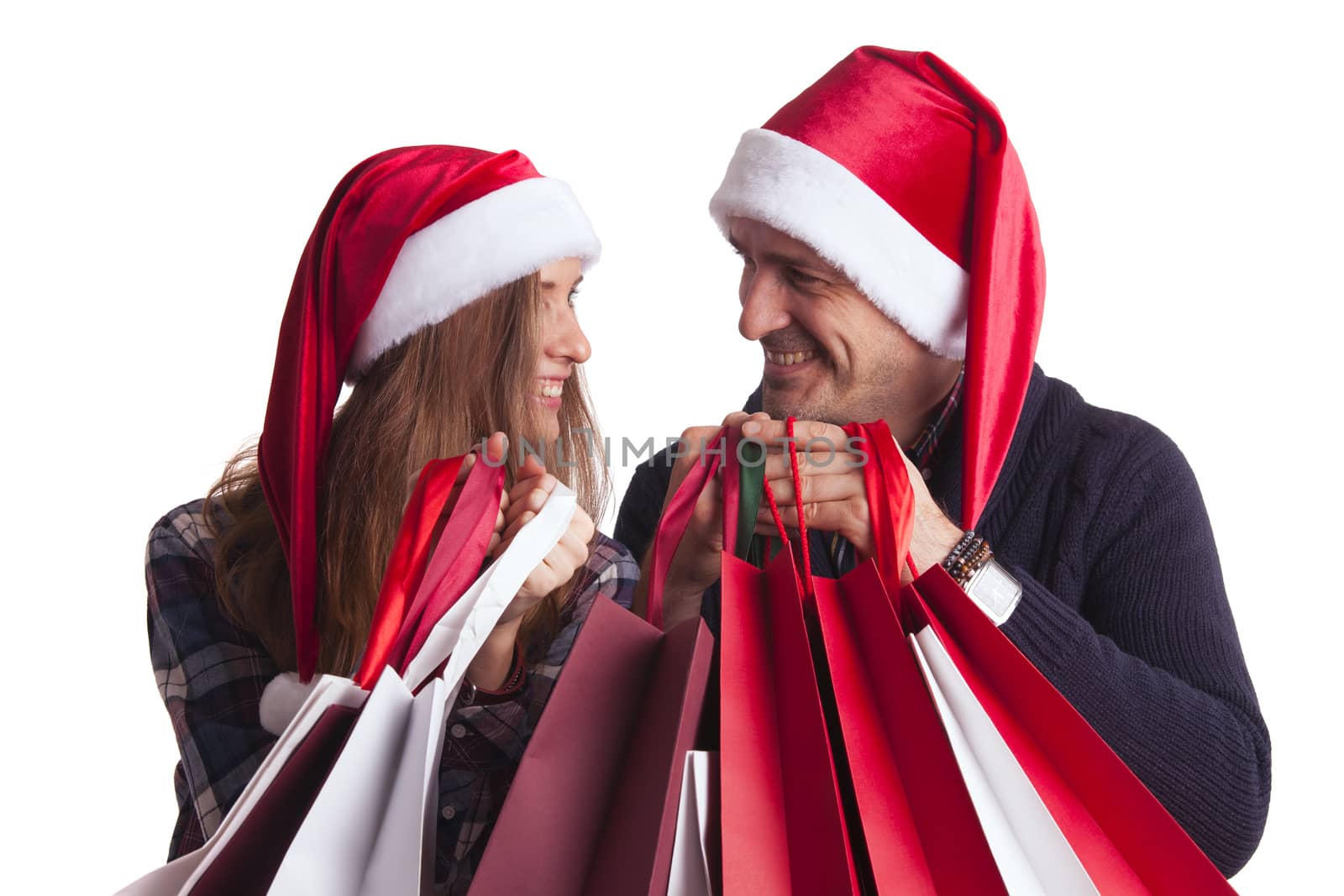 Happy beautiful couple holding many bags with christmas gifts isolated on white background