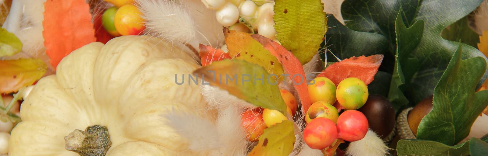 Bouquet of pumpkin and fluffy dried flowers in a basket on a gold background to decorate the table for thanksgiving celebration.