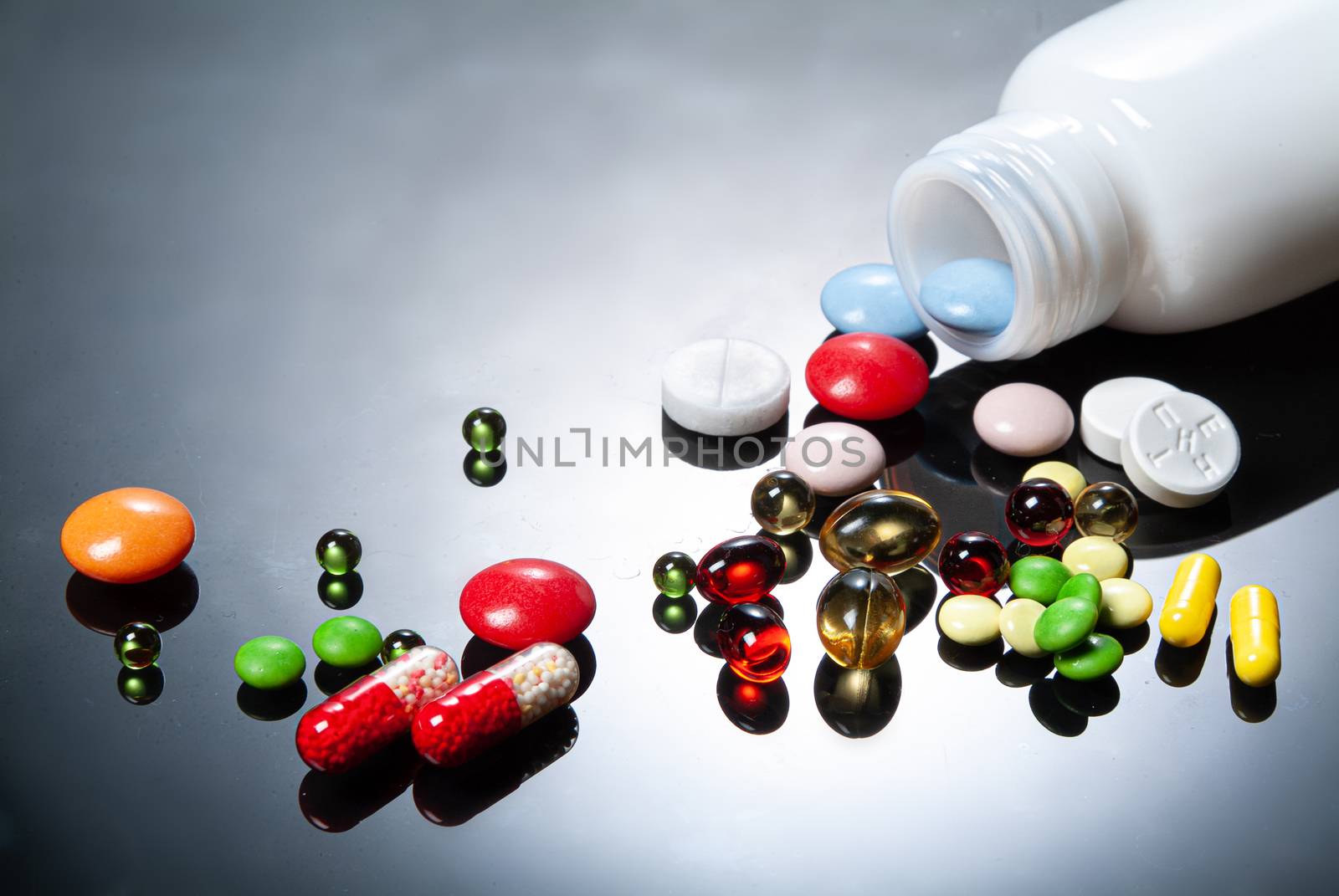 Different coloured drugs on a studio glass background