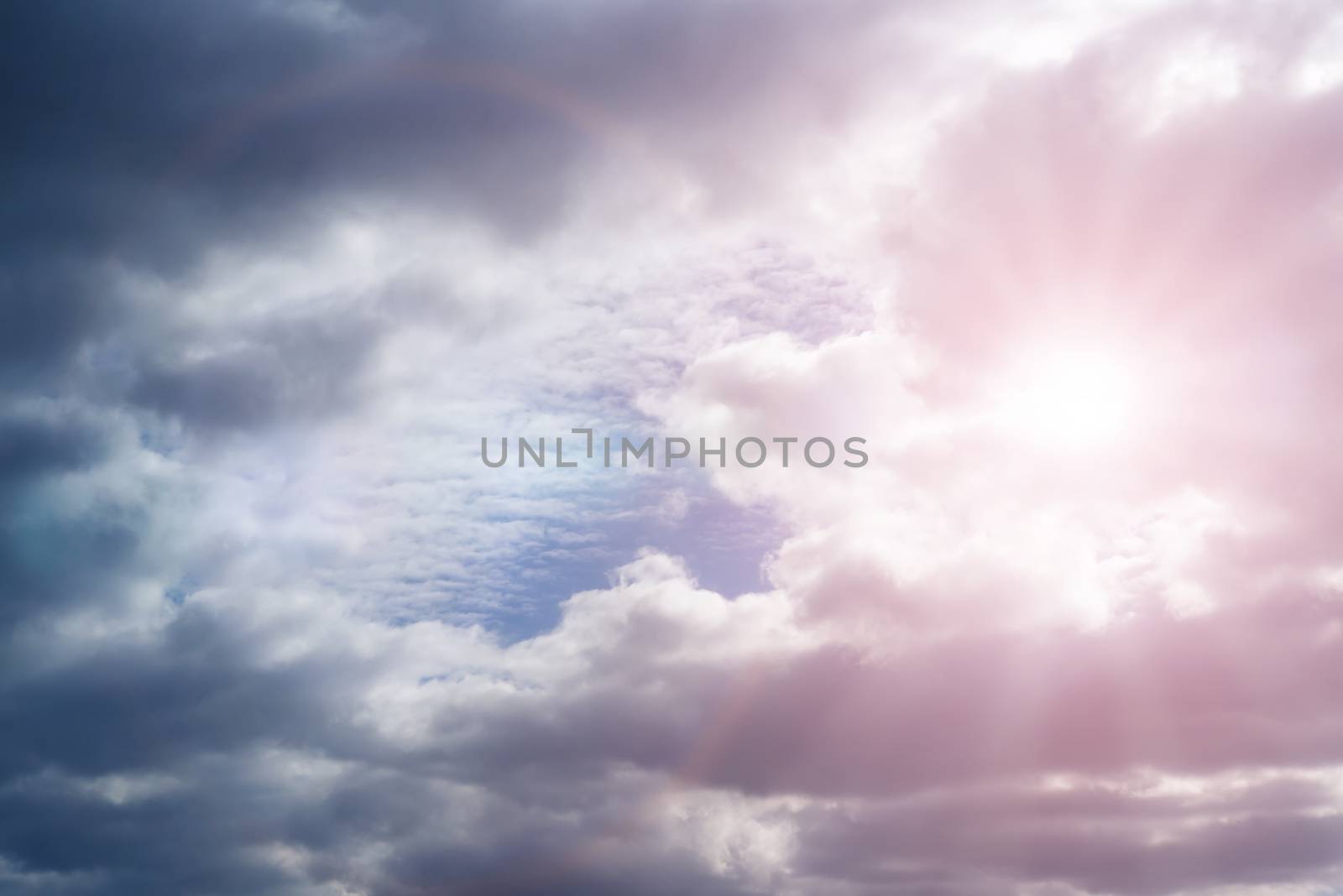 Sky with cumulus clouds and sunbeams on a summer day.