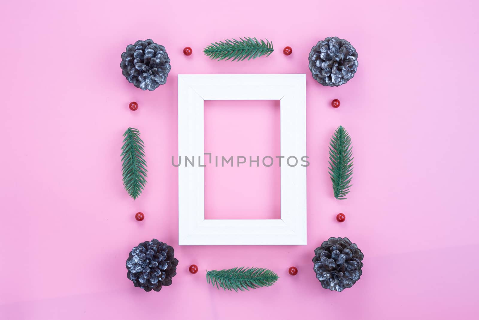 Christmas holidays composition, top view of red Christmas decorations and picture frame on pink background with copy space for text. Flat lay, winter, postcard template, new year concept.