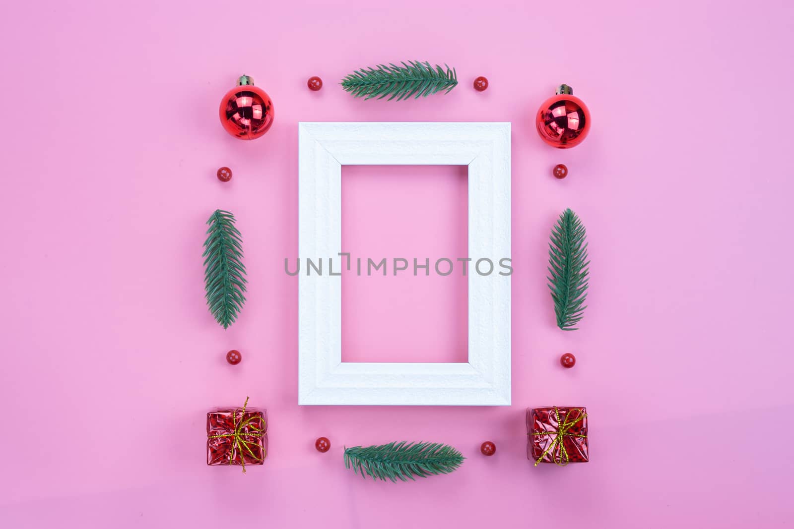 Christmas holidays composition, top view of red Christmas decorations and picture frame on pink background with copy space for text. Flat lay, winter, postcard template, new year concept.