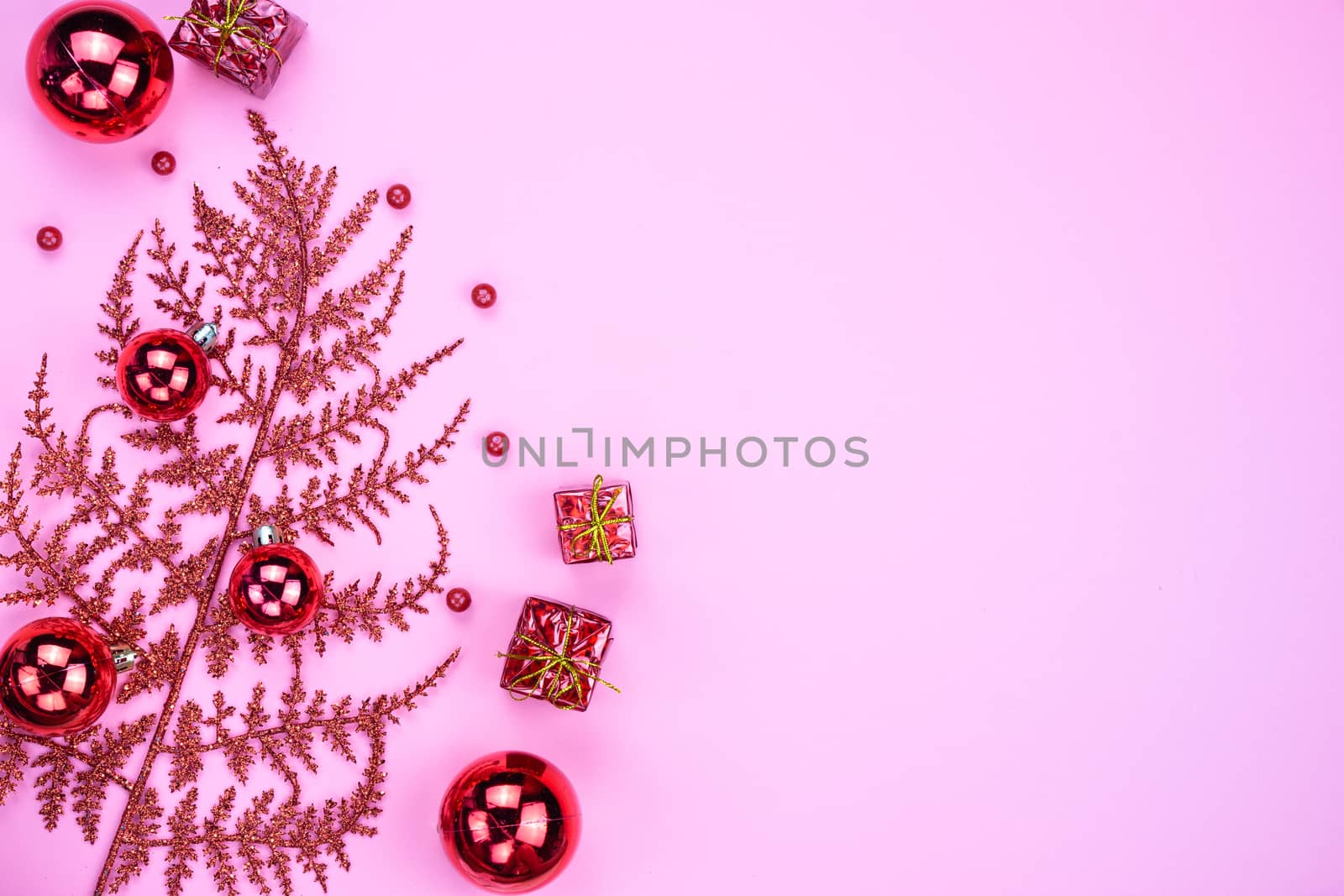 Christmas holidays composition, top view of red Christmas decorations on pink background with copy space for text. Flat lay, winter, postcard template, new year concept.