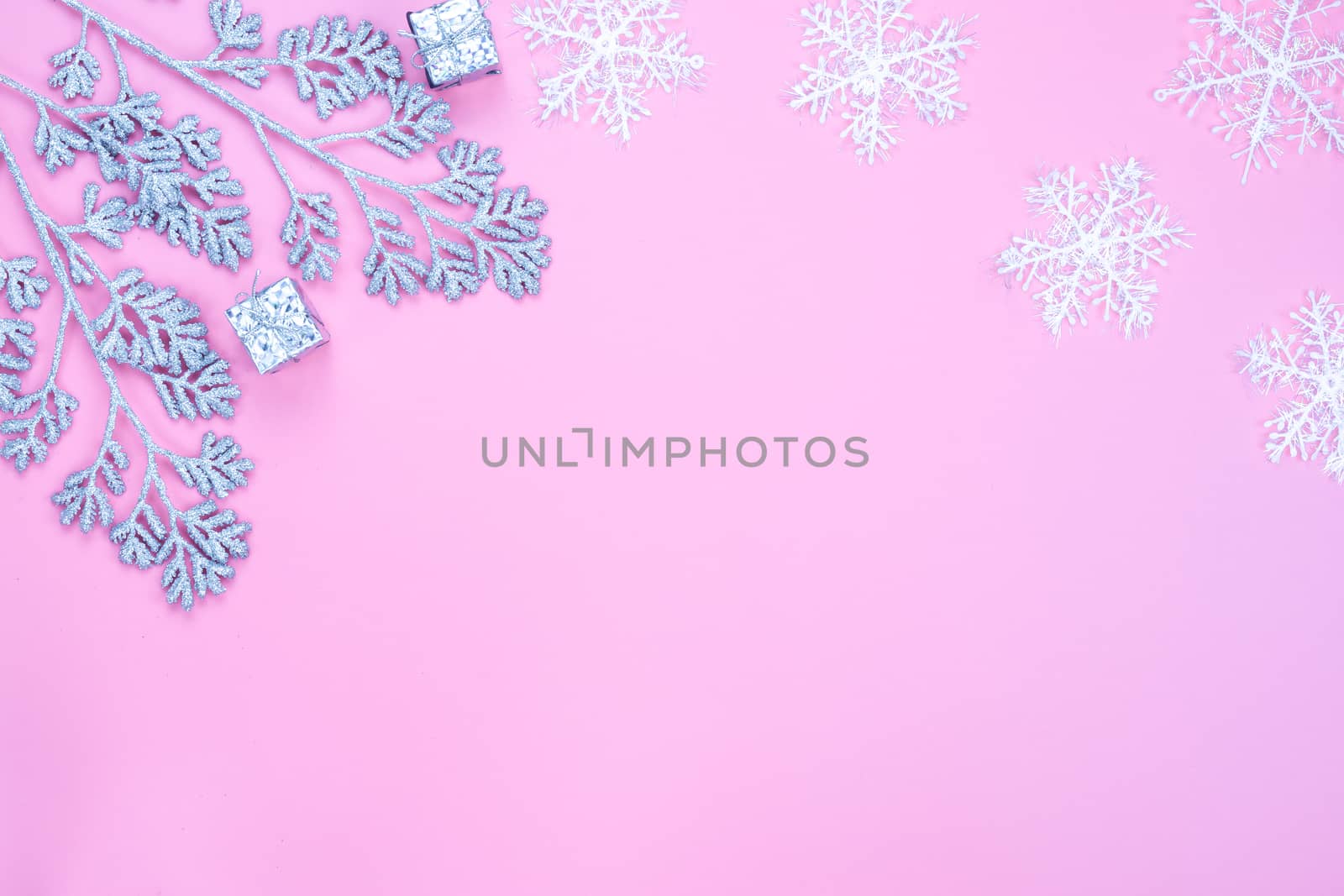 Christmas holidays composition, top view of silver Christmas decorations and snowflakes on pink background with copy space for text. Flat lay, winter, postcard template, new year concept.