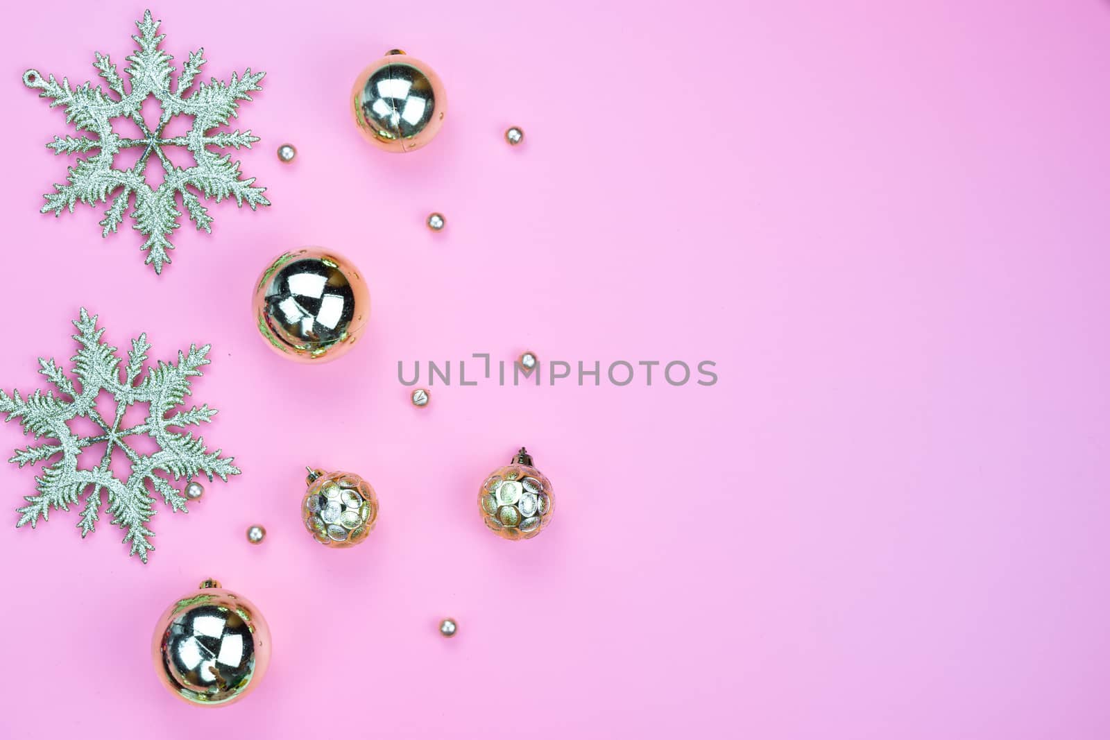 Christmas holidays composition, top view of gold Christmas decorations on pink background with copy space for text. Flat lay, winter, postcard template, new year concept.