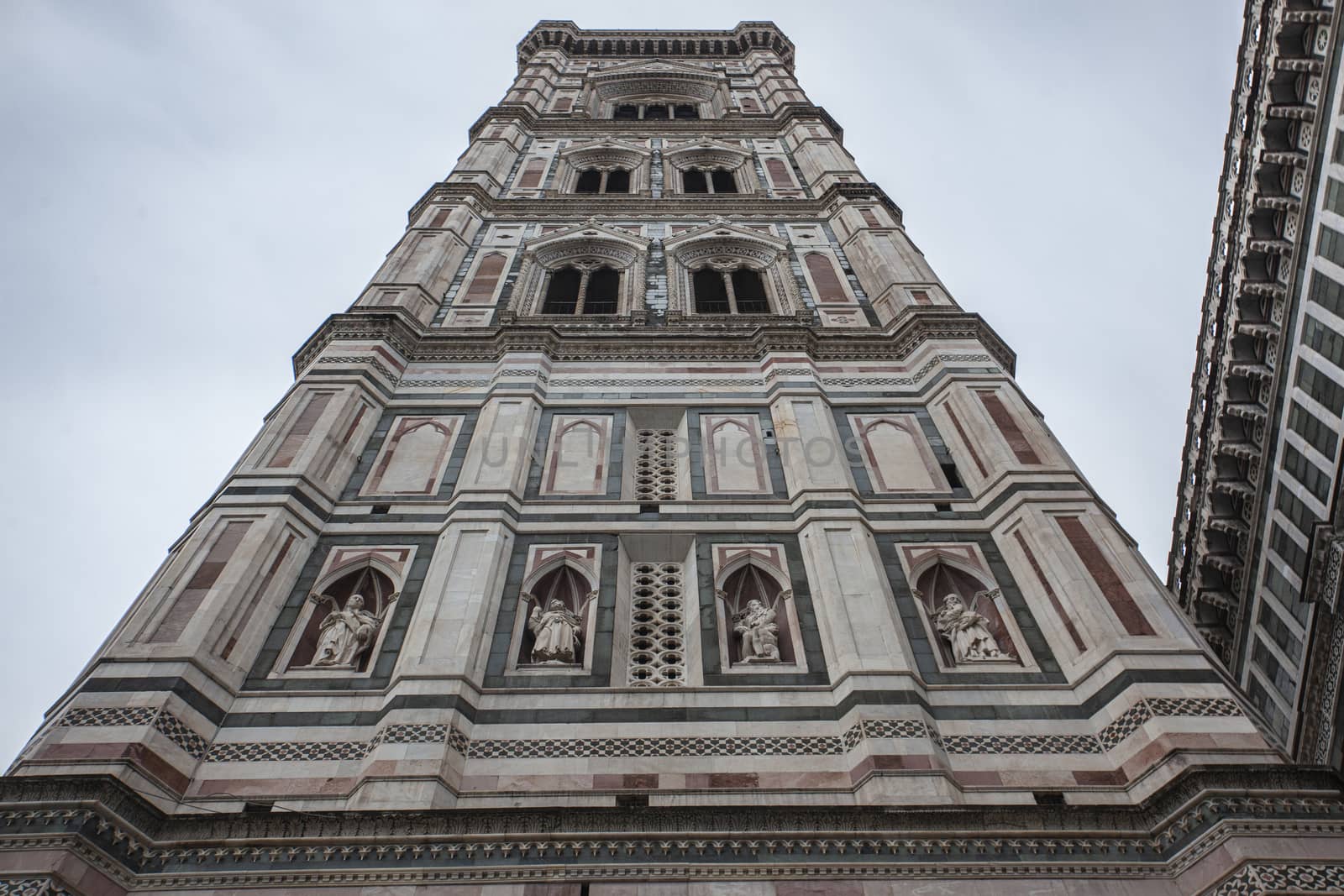 Detail of the bell tower of the Duomo of Florence shot on a cloudy day with the light that enhances the colors