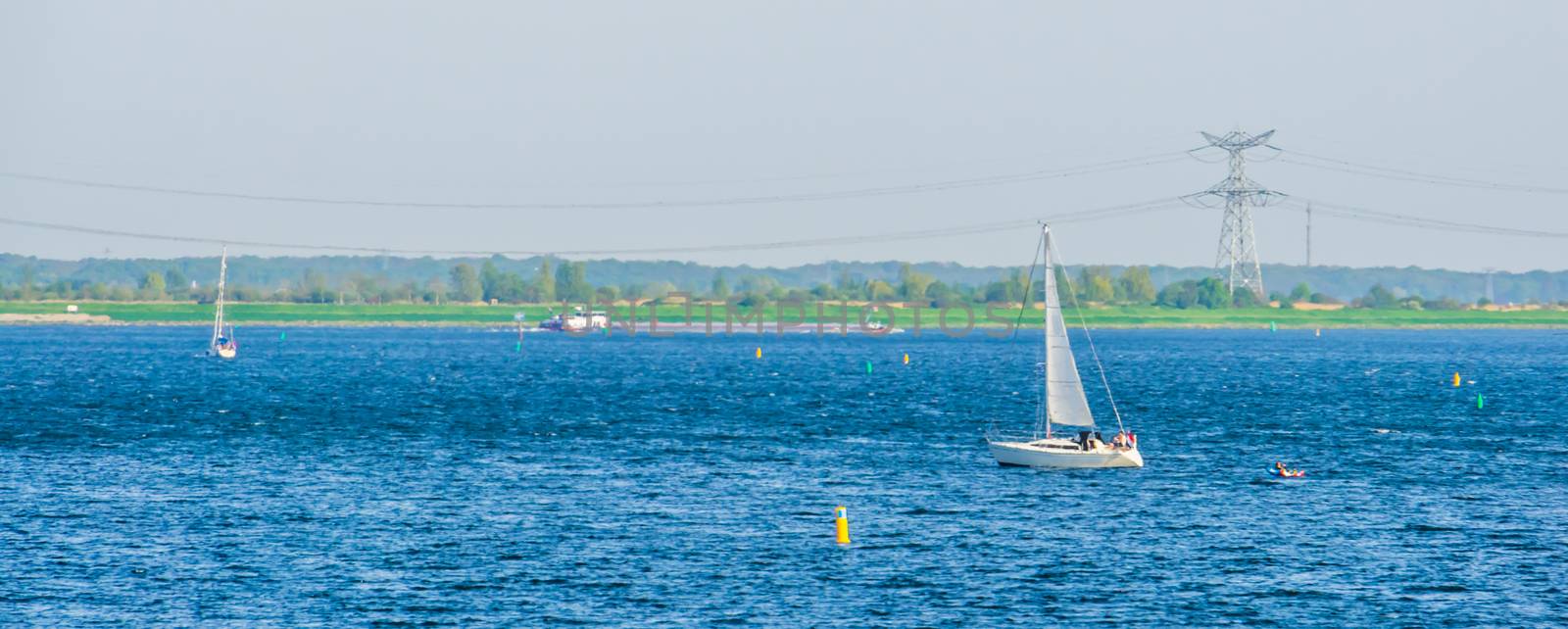 Boat sailing in the ocean of the Oosterschelde in Tholen city, Bergse diepsluis, Zeeland, The netherlands by charlottebleijenberg