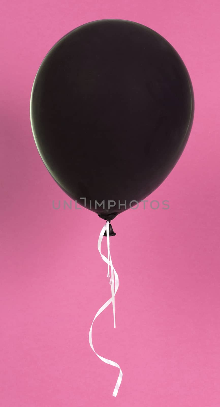 Black balloon isolated on a pink background