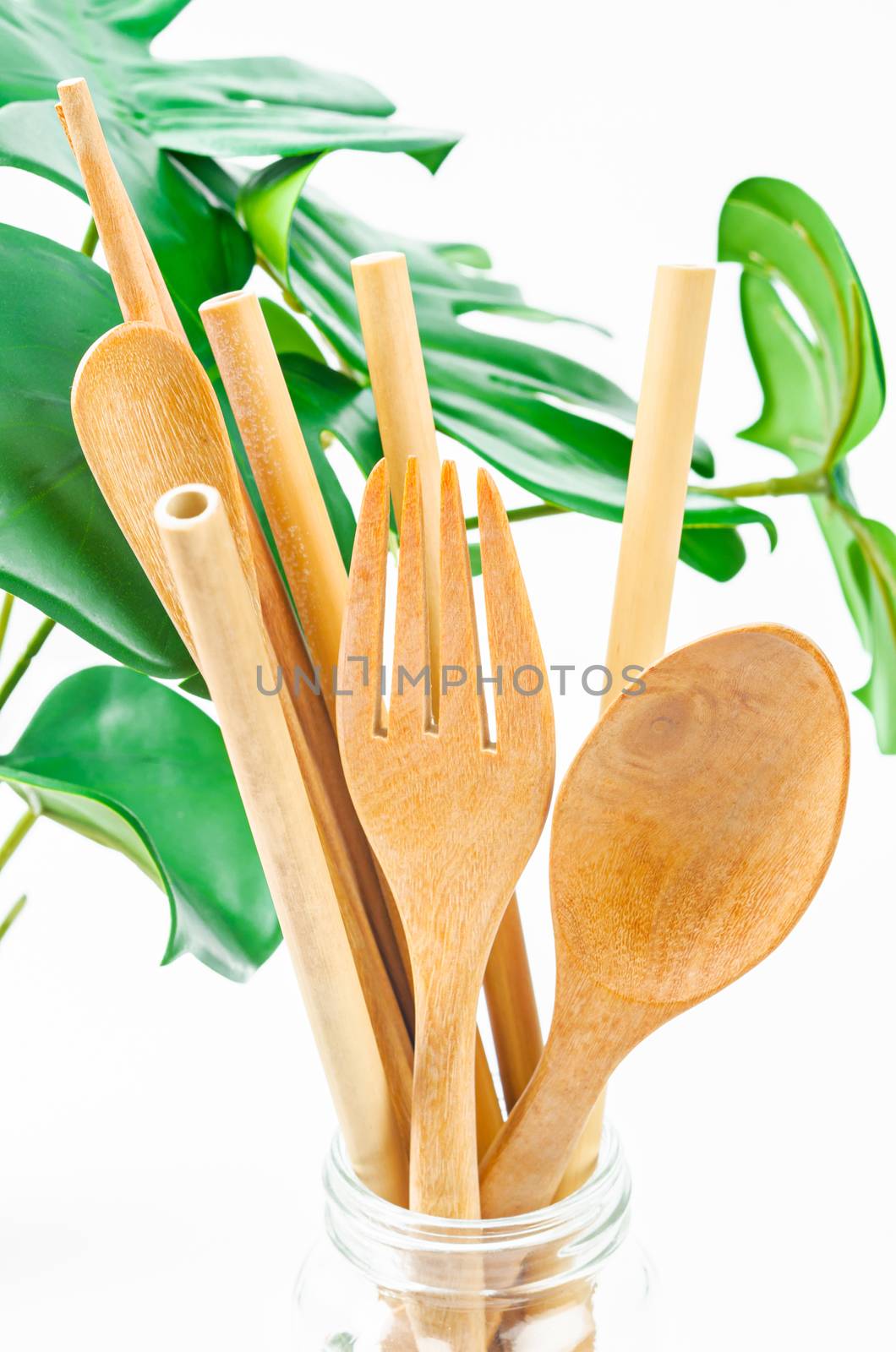 Bamboo straw tube for drink water and wooden utensil with green leaves. Eco friendly concept.