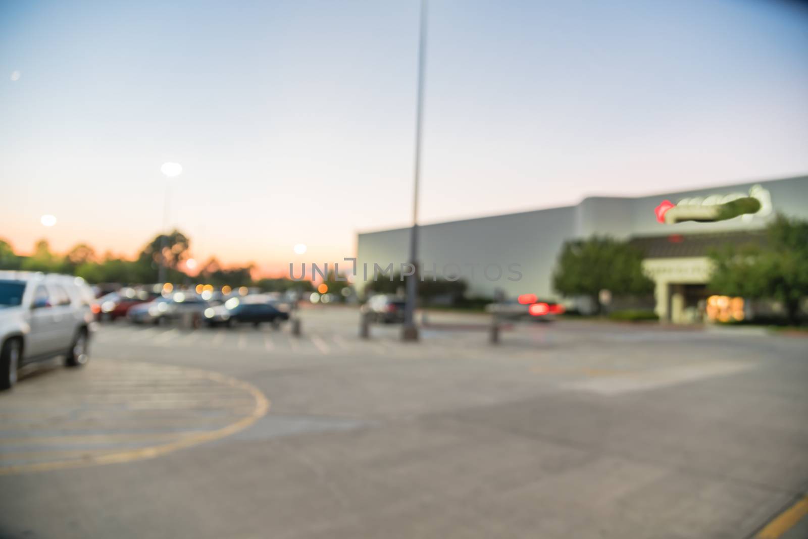 Blurry background exterior of retail stores of shopping mall in Houston, Texas at sunset by trongnguyen